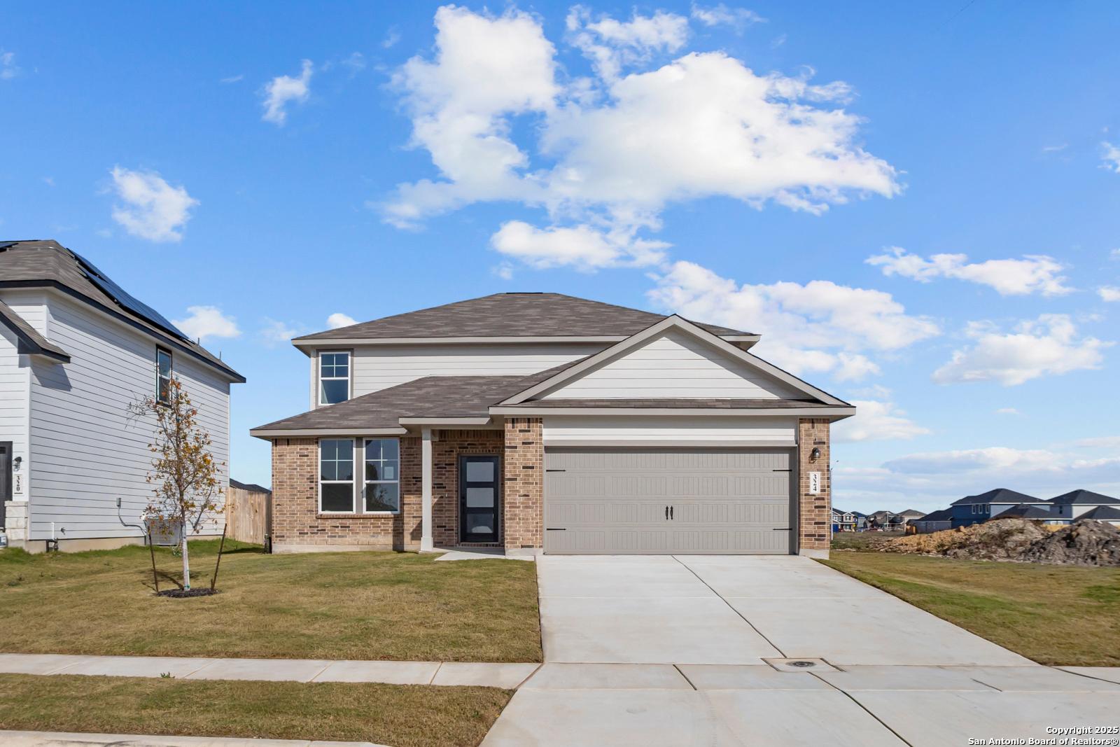 Modern 2-story Douglas C home exterior with 2-car garage, brick accents, and manicured lawn in Hannah Heights, Seguin, Texas