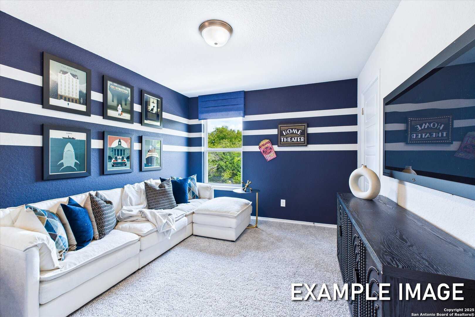 Navy blue media room with white striped walls, L-shaped sofa, mounted TV, art prints in Davidson Homes The Gillian B, San Antonio