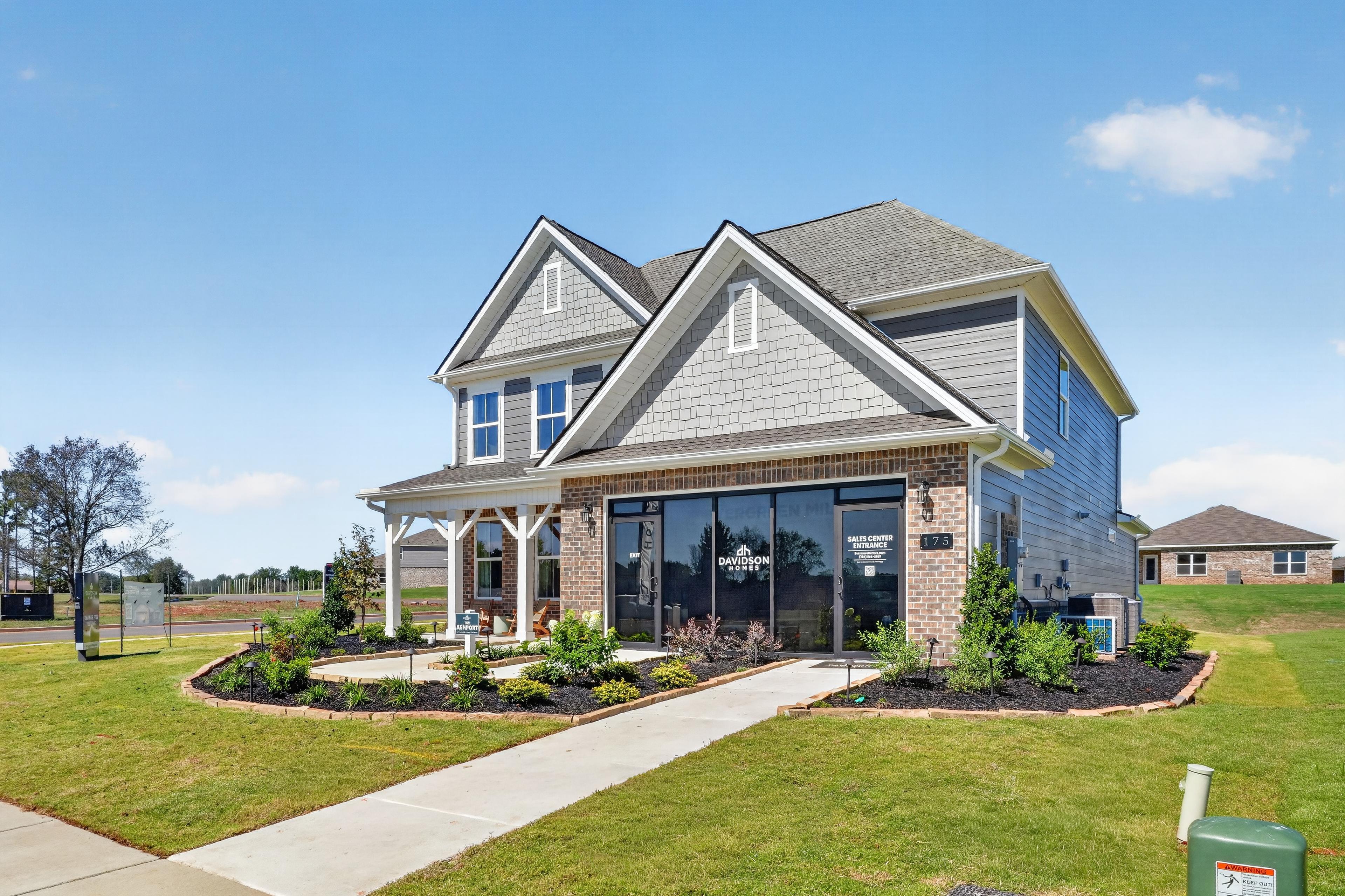 Davidson Homes sales center exterior at Evergreen Mill in Madison, Alabama with brick facade, covered porch, and landscaped yard