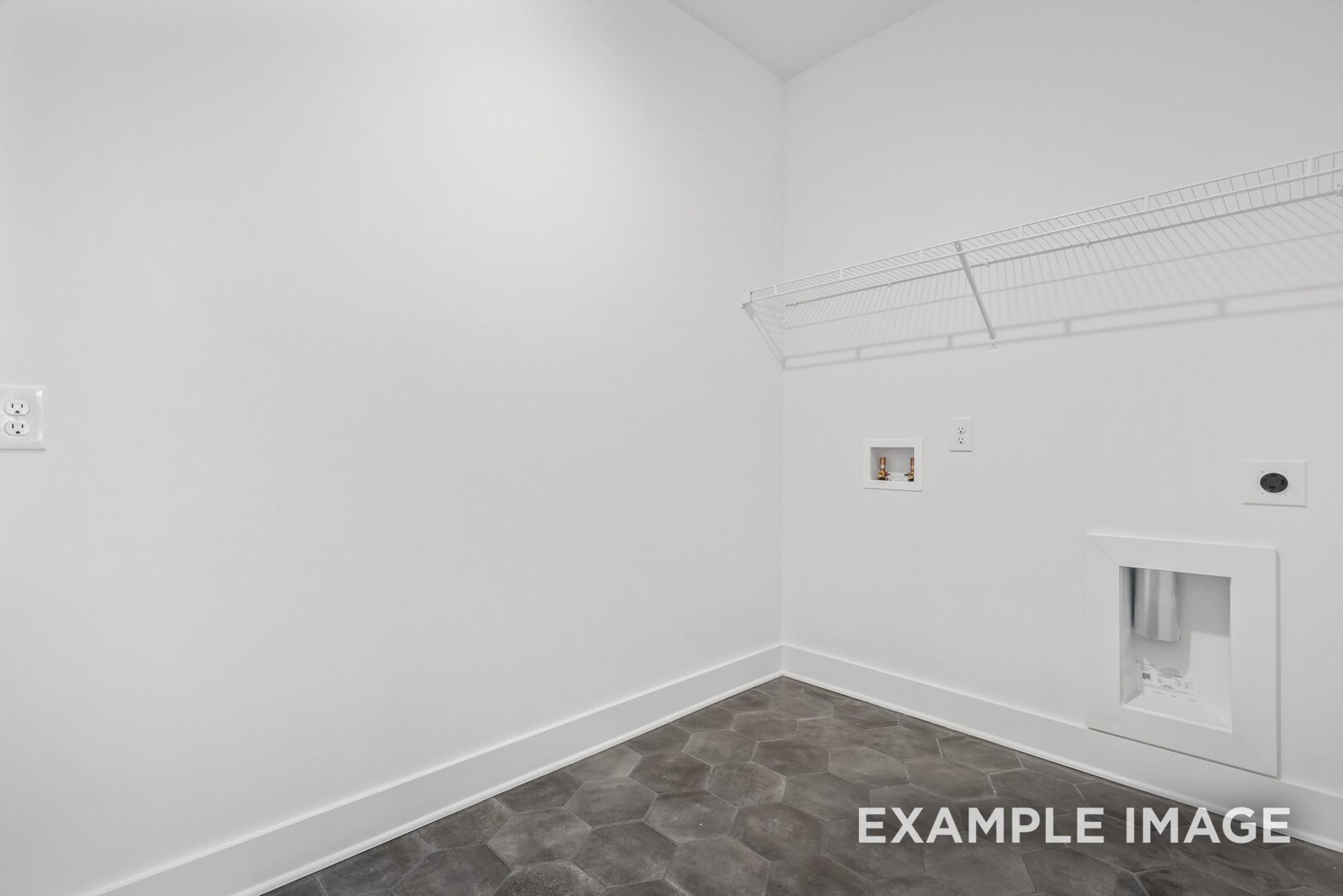 Bright laundry room with gray hexagonal tile floor, utility sink, and washer/dryer hookups in Davidson Homes The Ridgeport C, Gallatin, TN