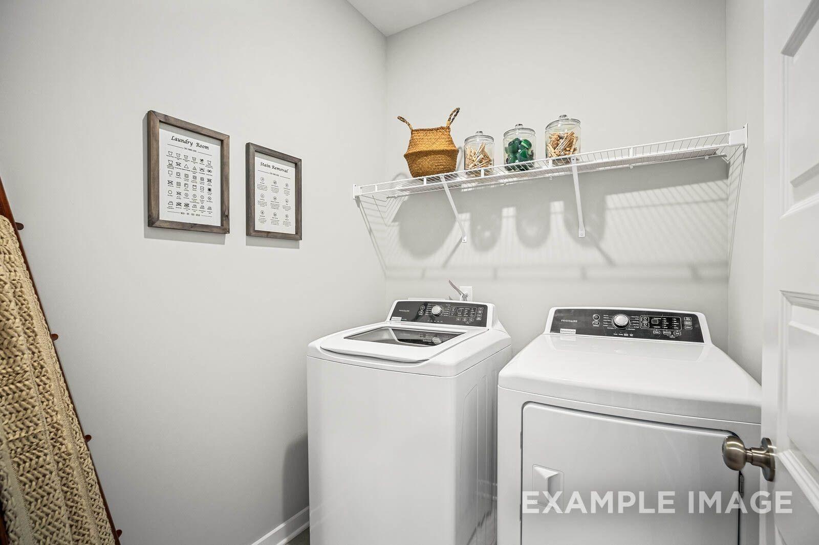 Modern laundry room featuring white washer-dryer set, wire shelving with baskets in Davidson Homes The Franklin B, White House, TN