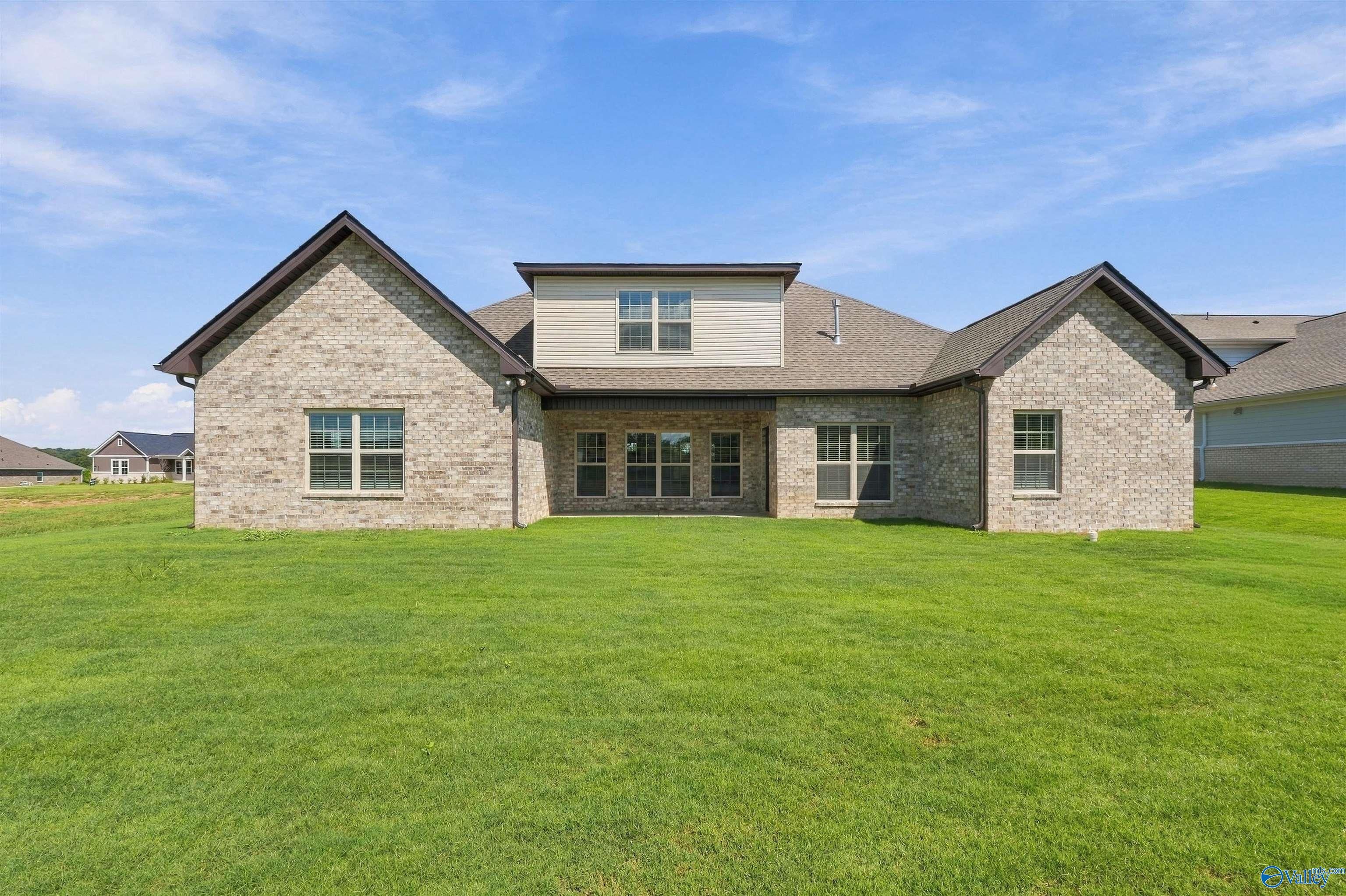 Rear exterior of brick one-story home with large backyard in Riverton Preserve, Davidson Homes Huntsville, Alabama