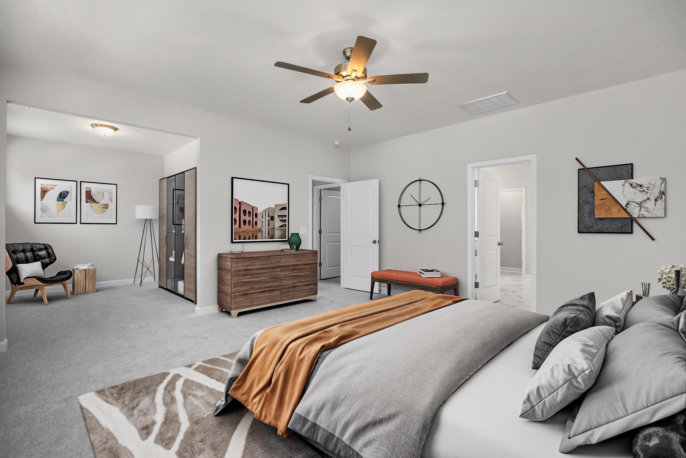 Spacious primary bedroom in Ashland Apex NC with king bed gray walls ceiling fan and modern artwork by Davidson Homes