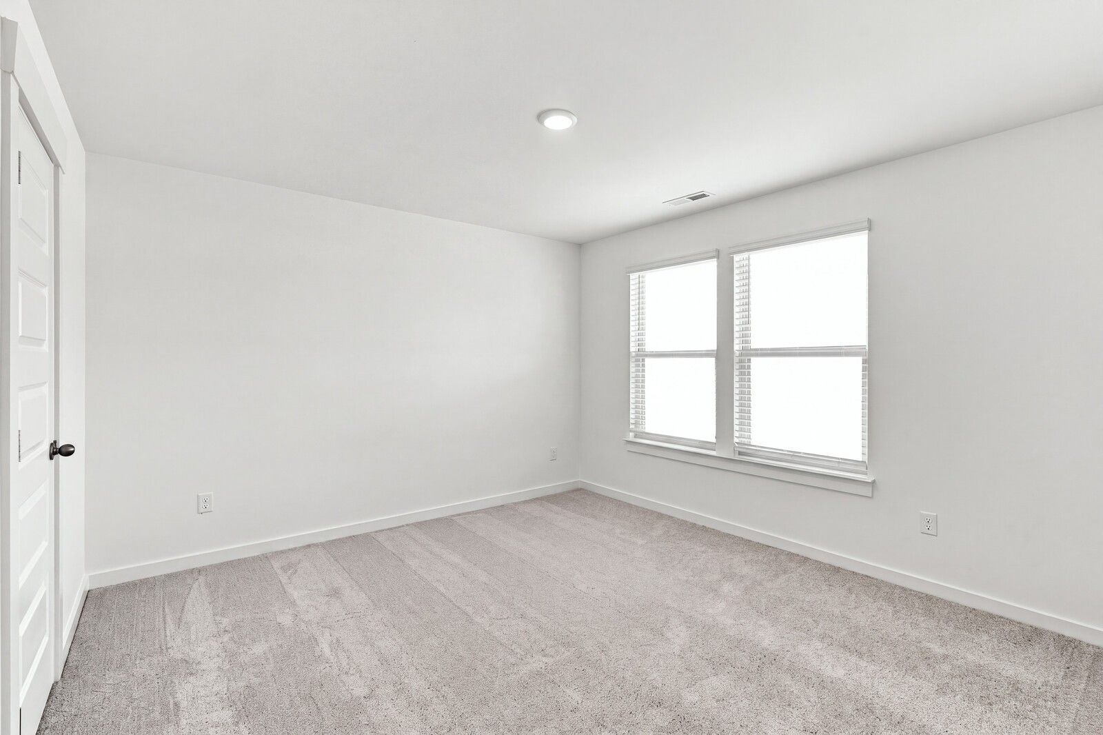Bright carpeted bedroom with double windows in The Willow C floor plan by Davidson Homes, Woods Crossing, Gallatin, TN