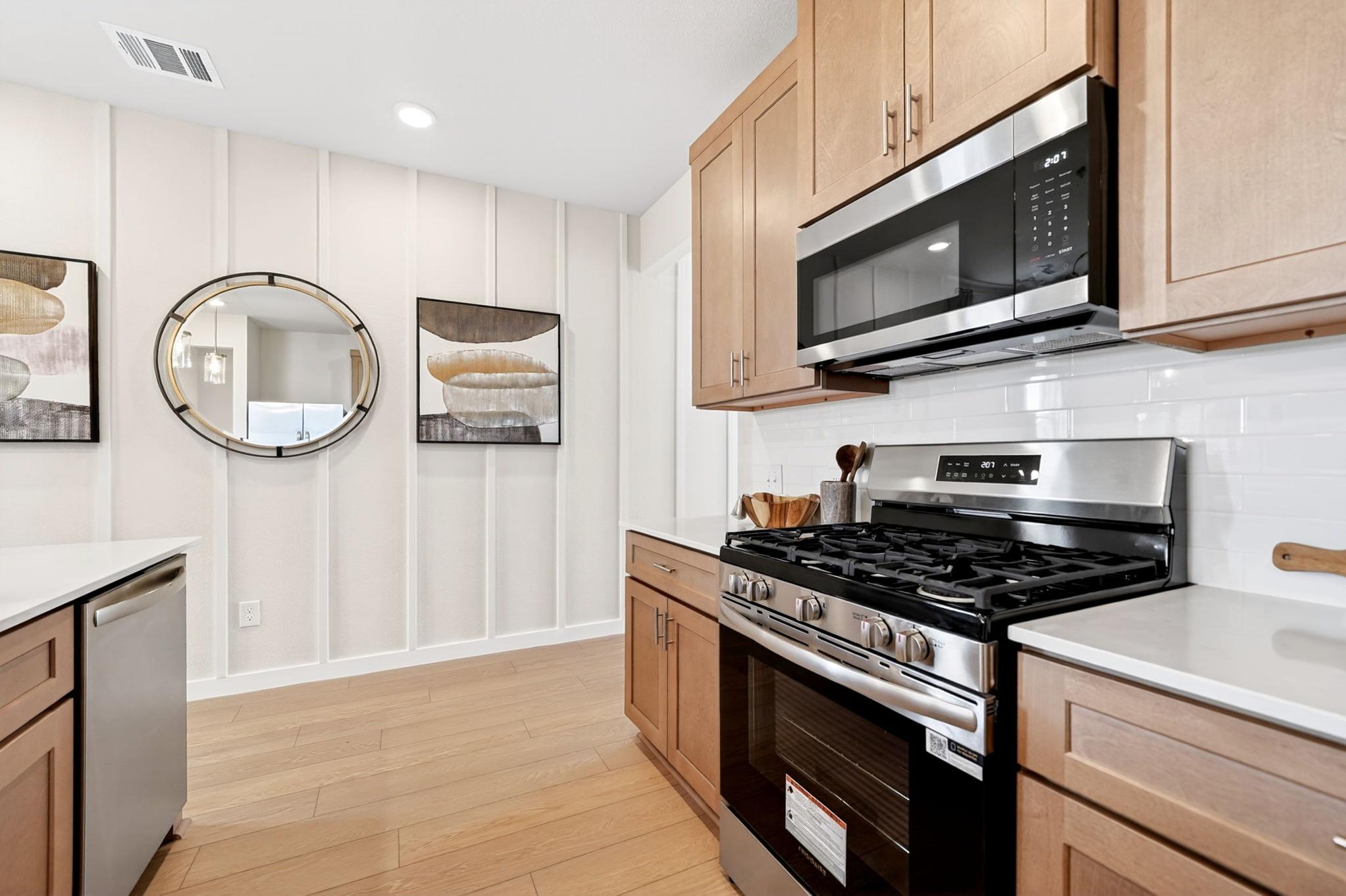 Modern kitchen at Mesa Vista in San Antonio with wood cabinets, stainless steel appliances, and board and batten walls.