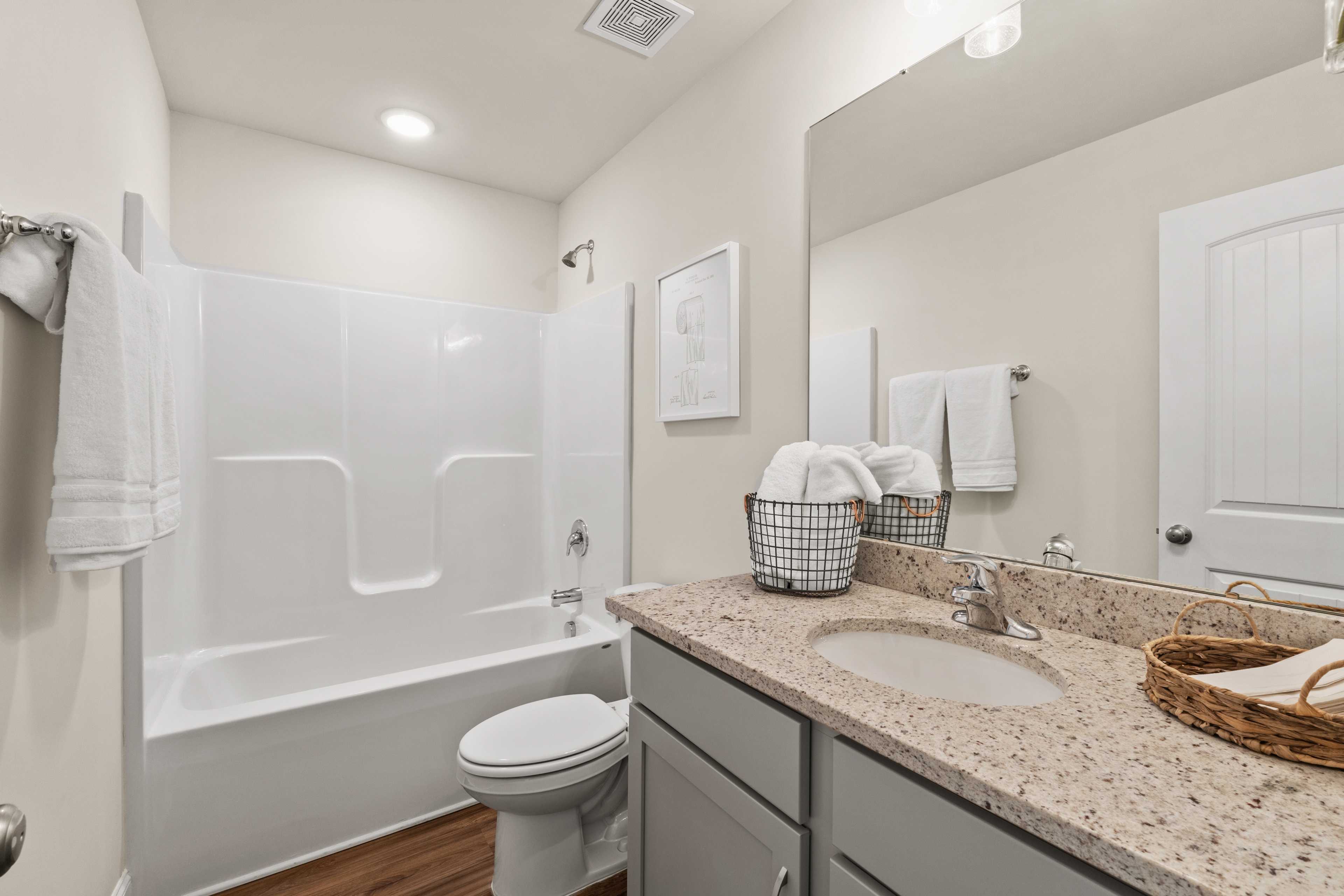 Spacious bathroom at Ramsay Cove in Owens Cross Roads AL with tub shower combo, granite vanity, hardwood floors