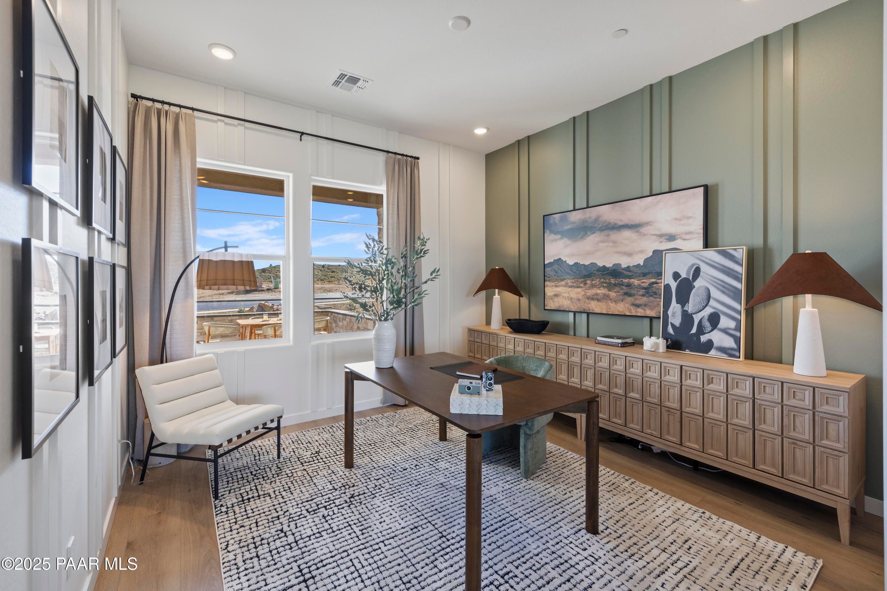 Modern home office with desert-view windows, wooden desk, credenza, and art in Davidson Homes The Blaze D, Prescott Arizona