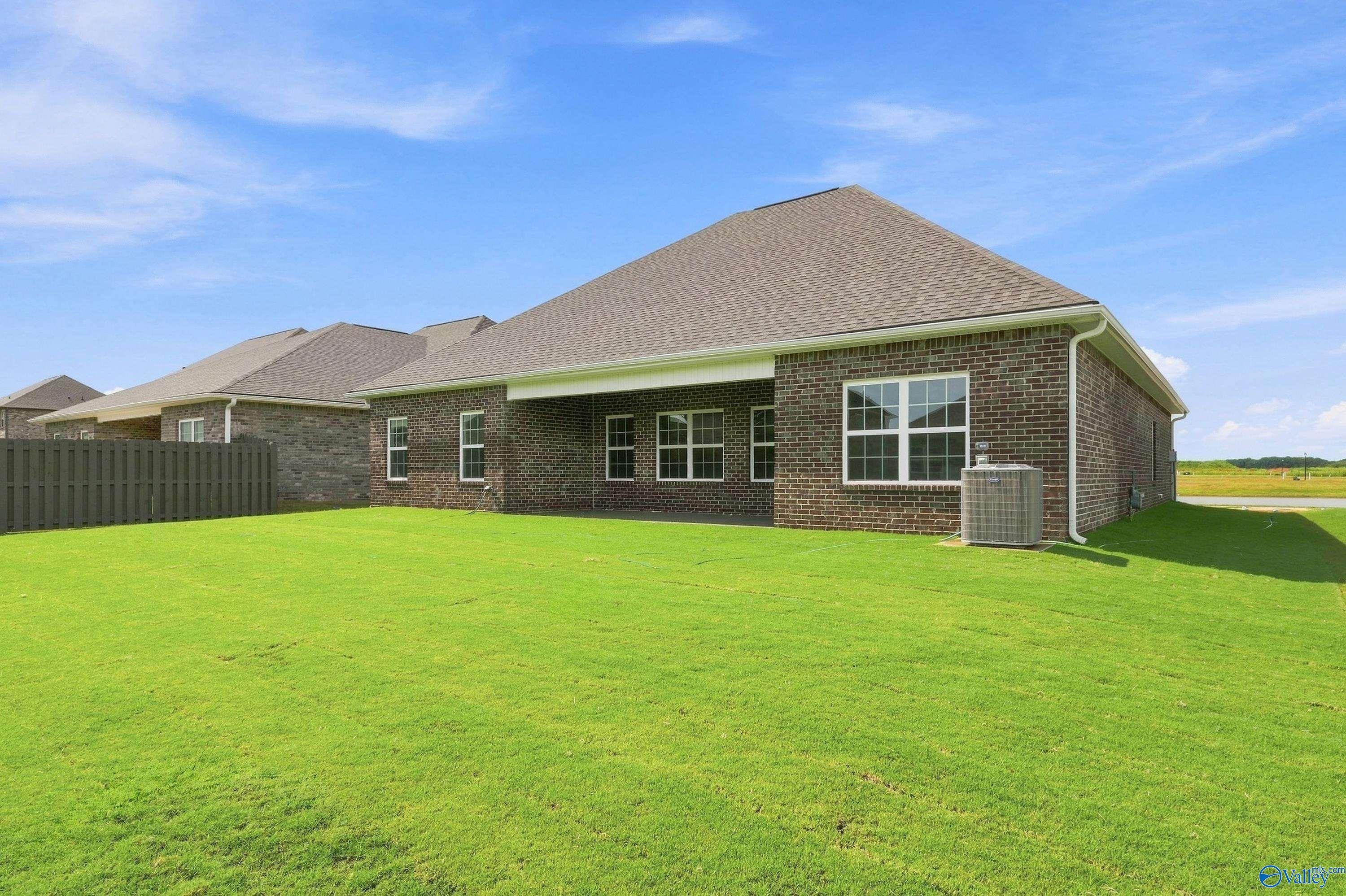 Brick exterior of The Rockford B floor plan with spacious backyard in Kendall Downs, Toney, Alabama.