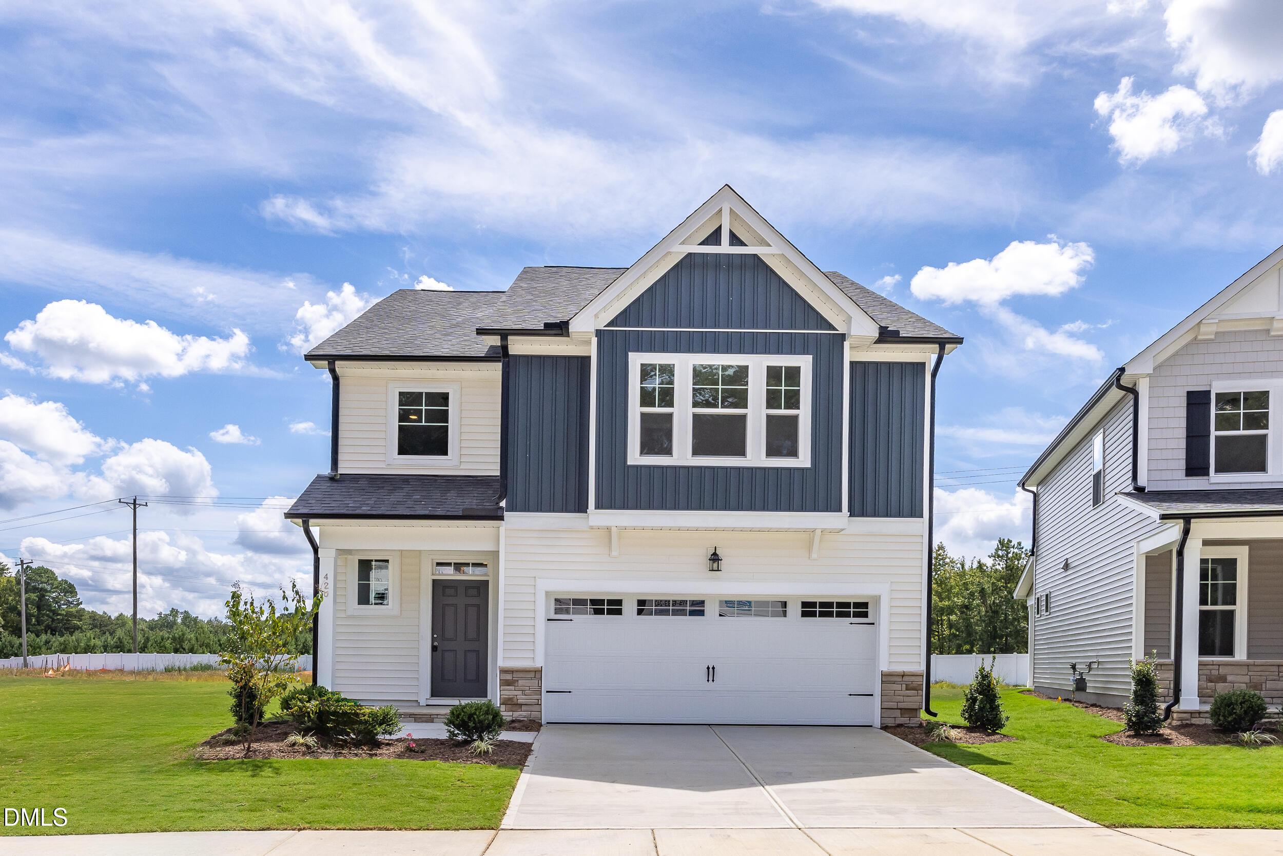 Modern two-story navy blue home with 2-car garage, white trim, and landscaped yard in Gregory Village, Lillington, NC - Davidson Homes Adalynn B