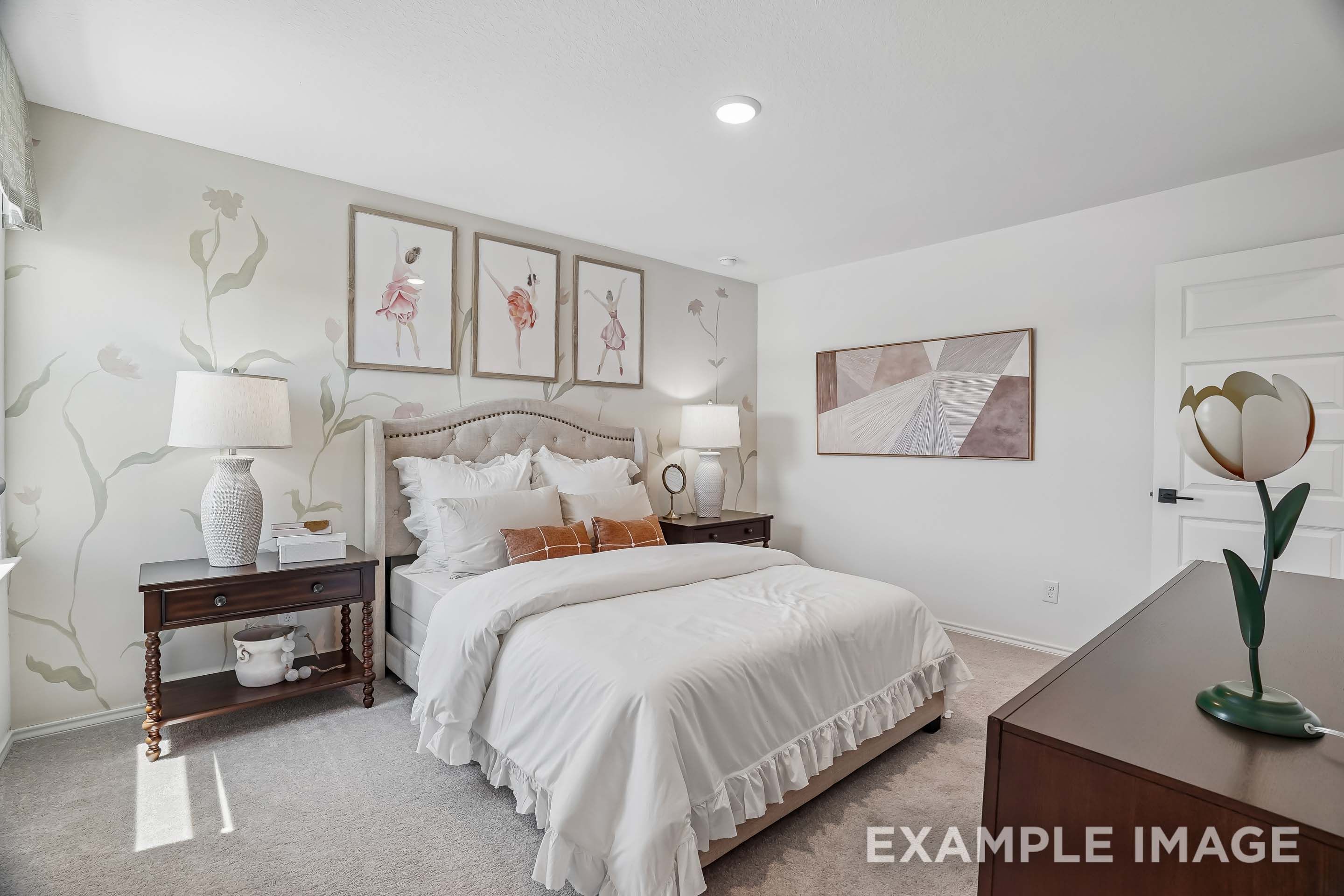 Cozy master bedroom in The Pinecrest featuring a tufted headboard, floral wall mural, and elegant ballerina wall art.