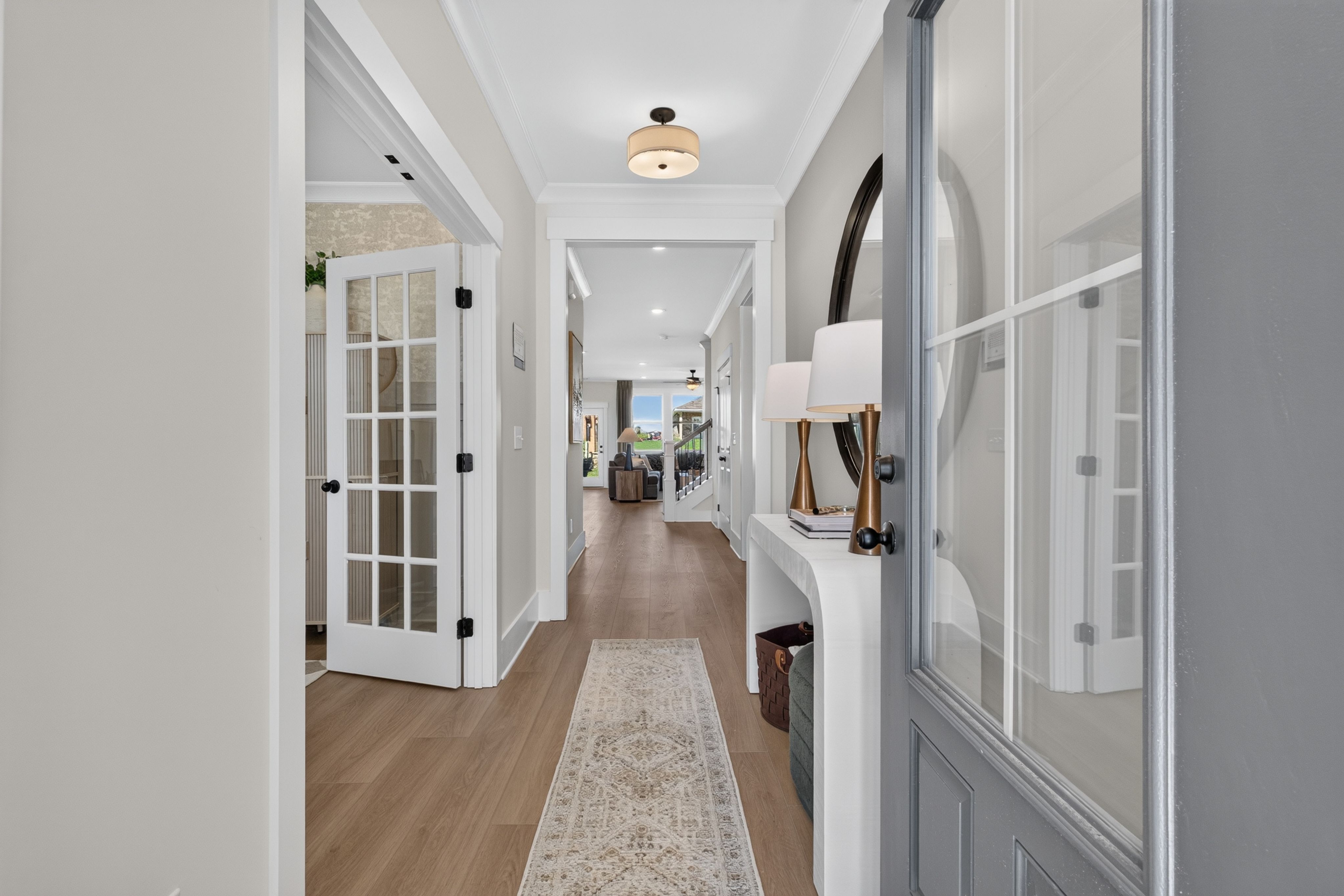 Bright entryway foyer at Evergreen Mill in Madison, Alabama by Davidson Homes with hardwood floors and glass panel doors
