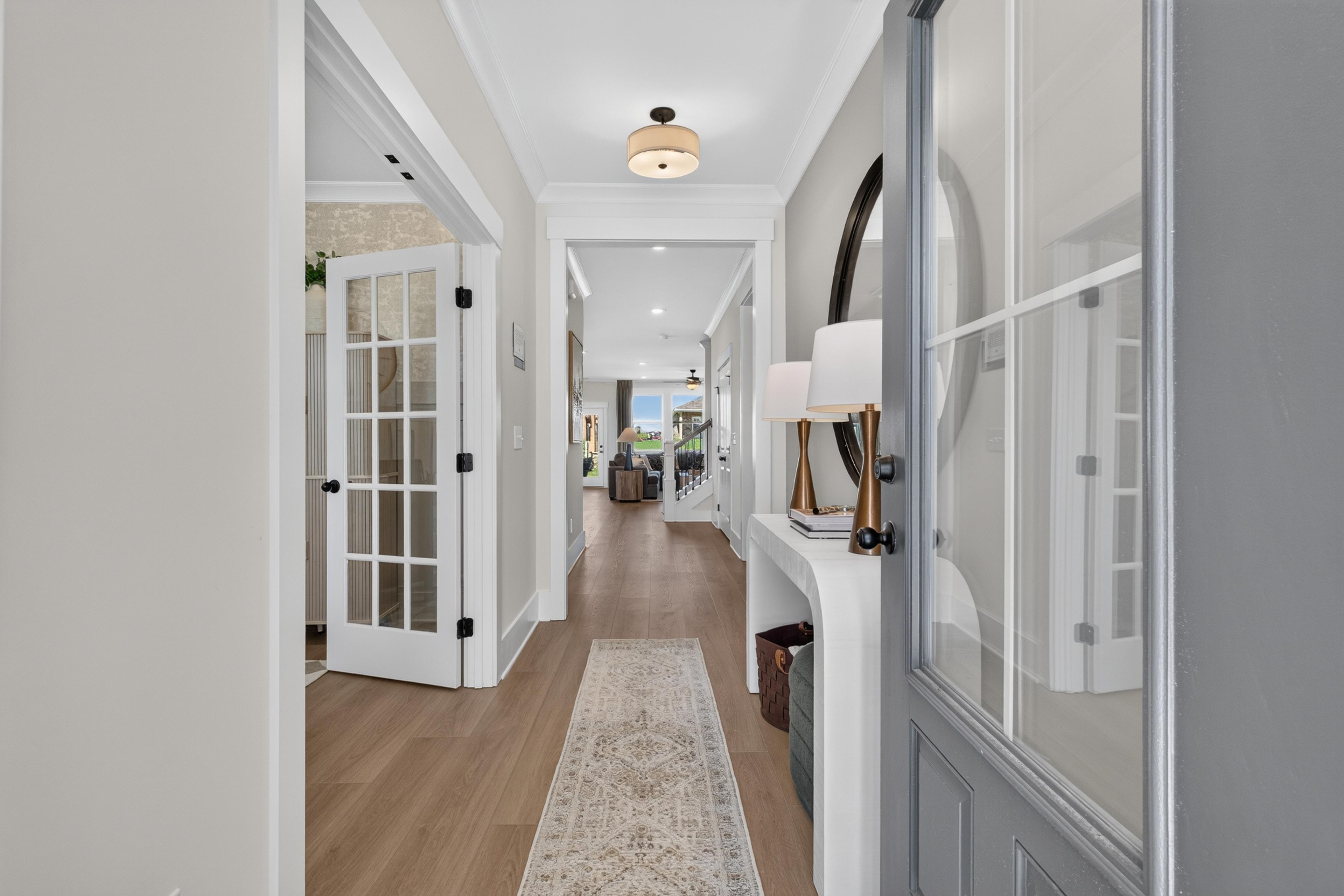 Bright entryway foyer at Evergreen Mill in Madison, Alabama by Davidson Homes with hardwood floors and glass panel doors