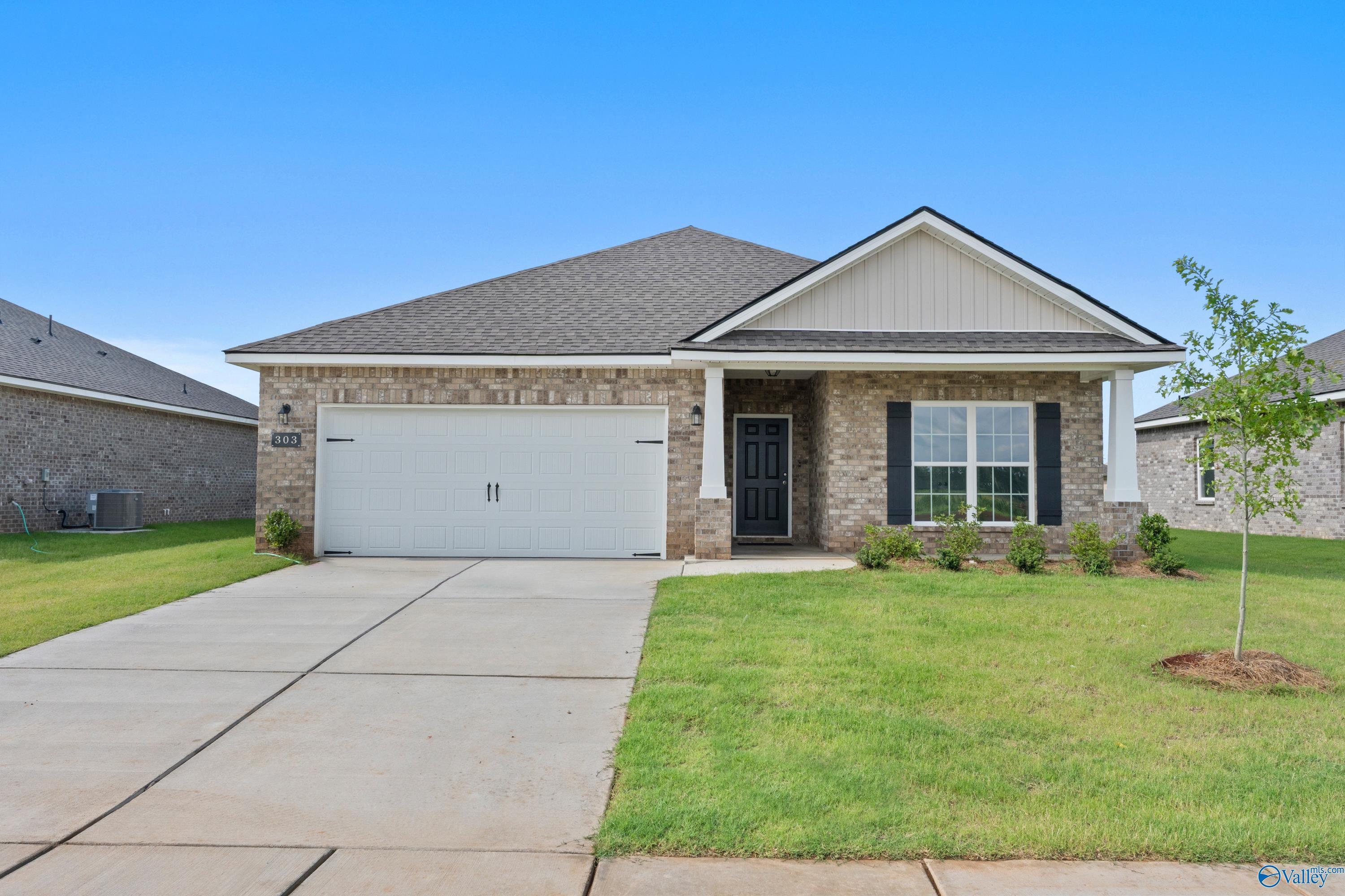 Modern single-story brick home exterior with 2-car garage, driveway, and lush green yard in Ivy Hills, Toney, Alabama