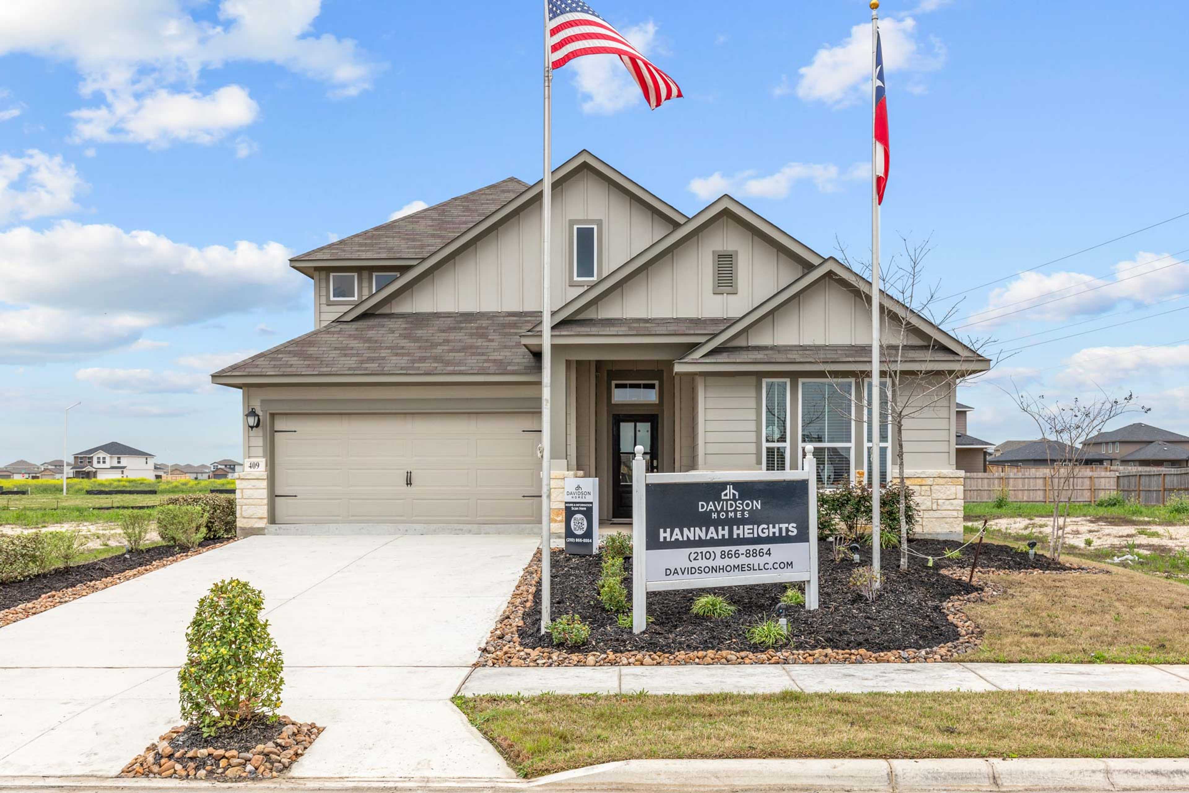 Modern two-story home exterior at Hannah Heights in Seguin Texas by Davidson Homes with American and Texas flags