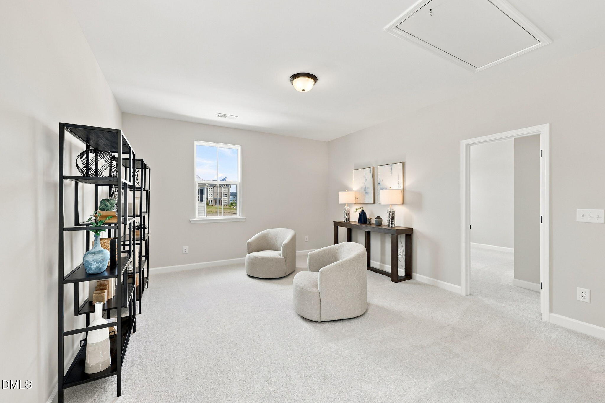 Bright, carpeted loft area with modern chairs and shelving in The Harris C floor plan at Forestville Yard, Knightdale, NC.