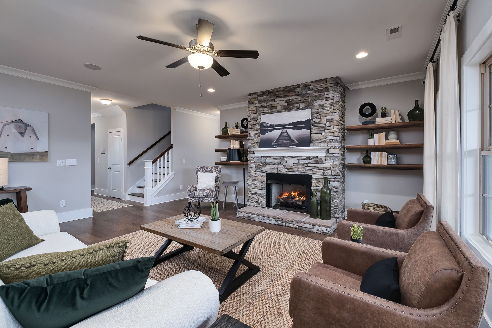 Cozy living room with stone fireplace, hardwood floors, and plush seating at Chimney Creek in Hampton Cove, Alabama