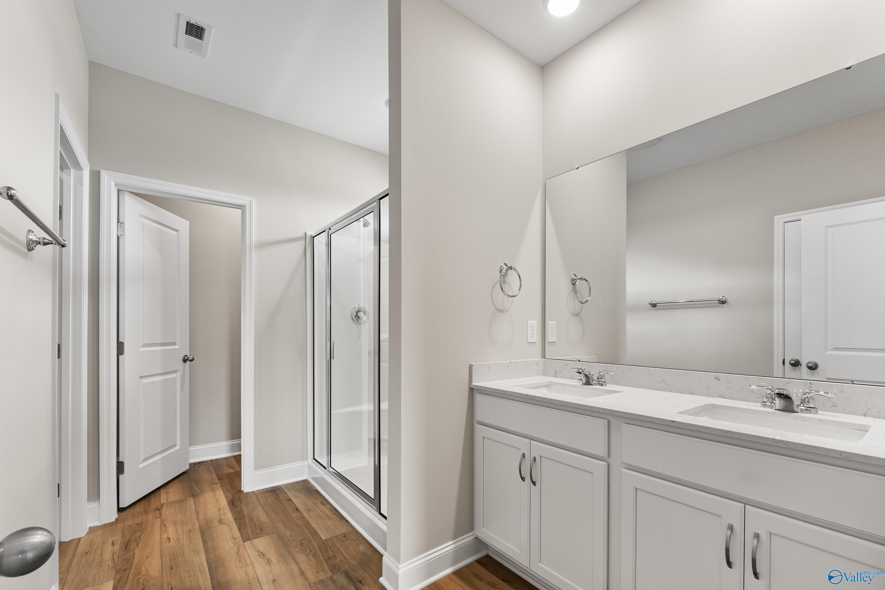 Modern master bathroom featuring double vanity, large mirror, and walk-in glass shower in Davidson Homes The Daphne C, Harvest, Alabama