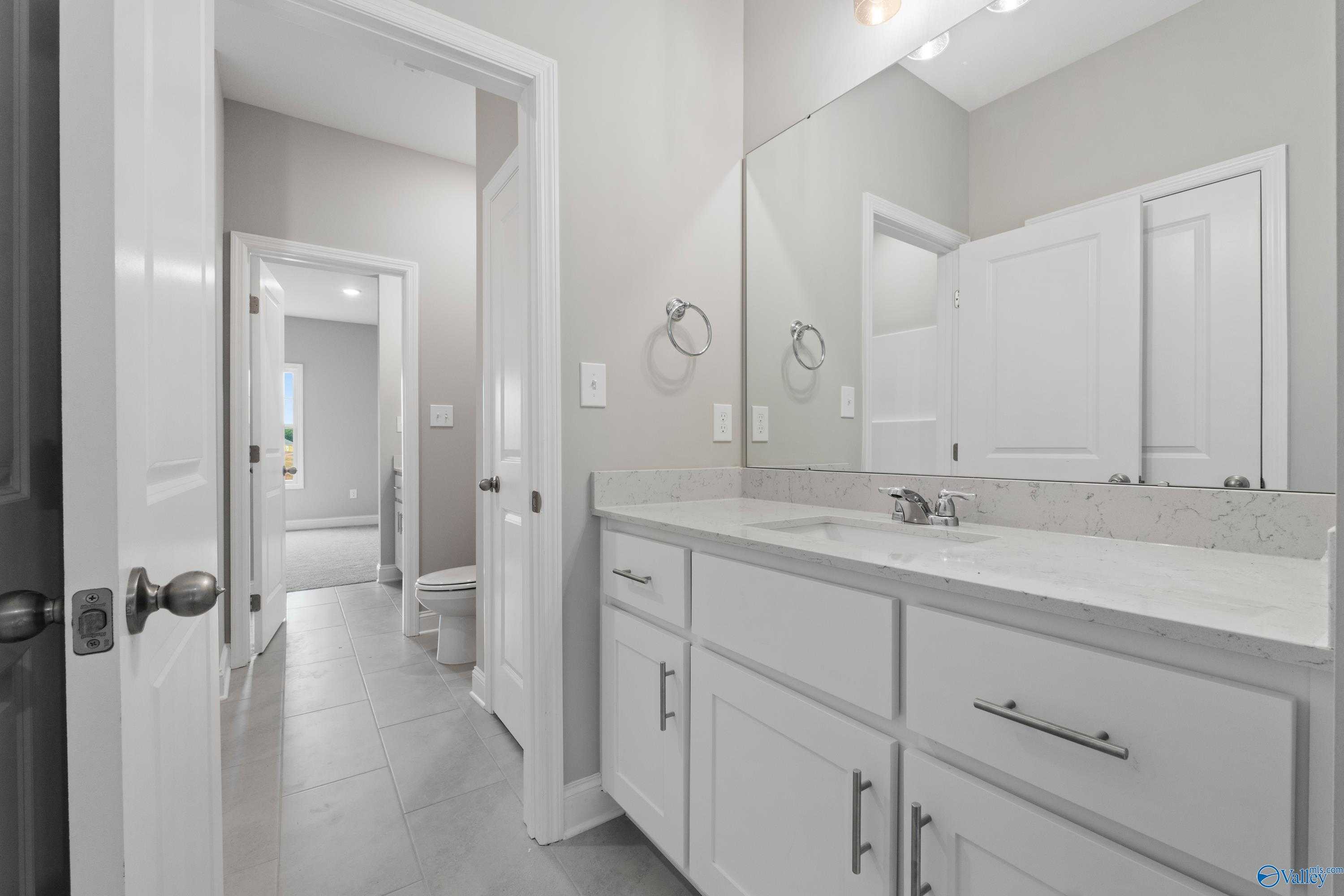 Modern master bathroom with white shaker vanity, quartz counters, and subway tile accents in Davidson Homes The Finleigh, Meridianville, Alabama