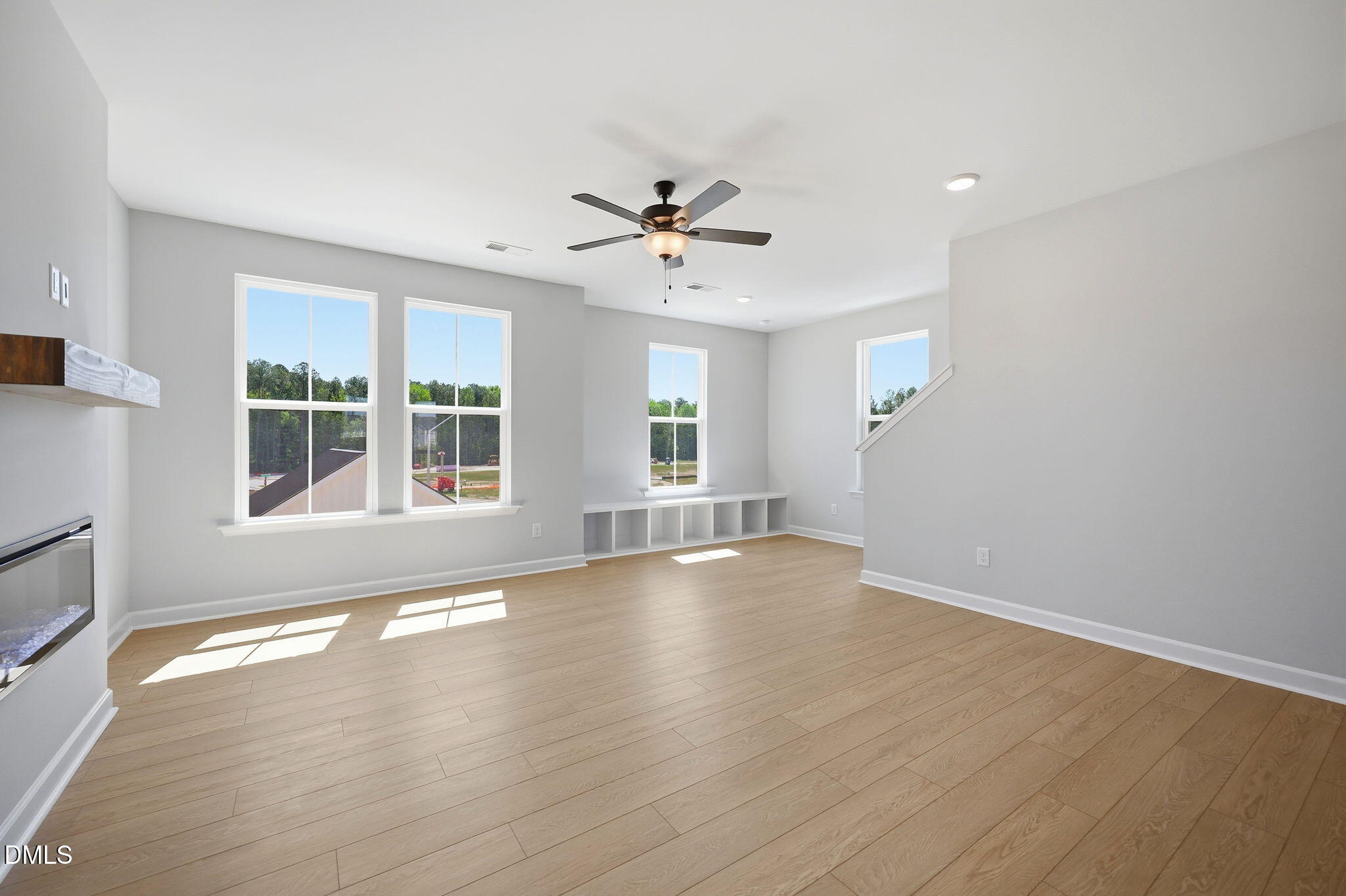 Spacious living room with modern fireplace and built-in shelving in The Avery floor plan at Forestville Yard, Knightdale.