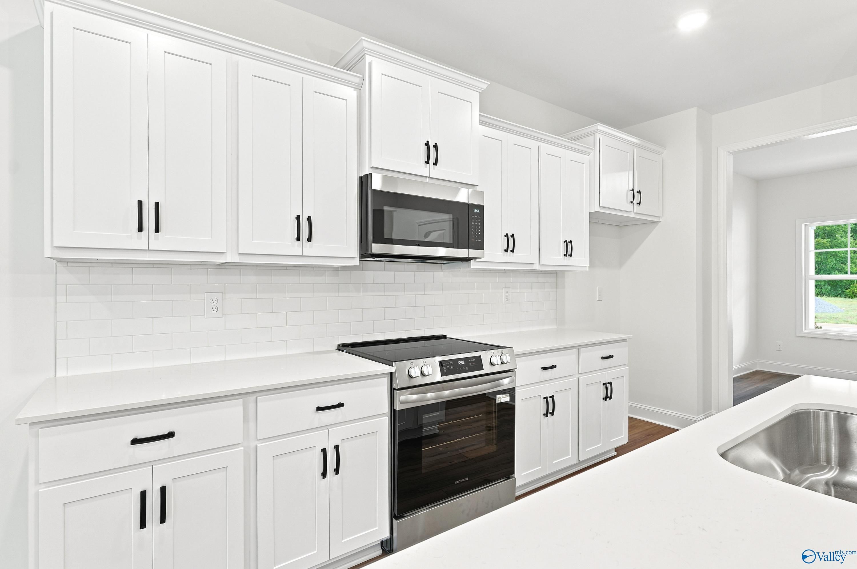Modern kitchen with white shaker cabinets, subway tile backsplash, and stainless appliances in Noble Ridge home, Cullman, AL.