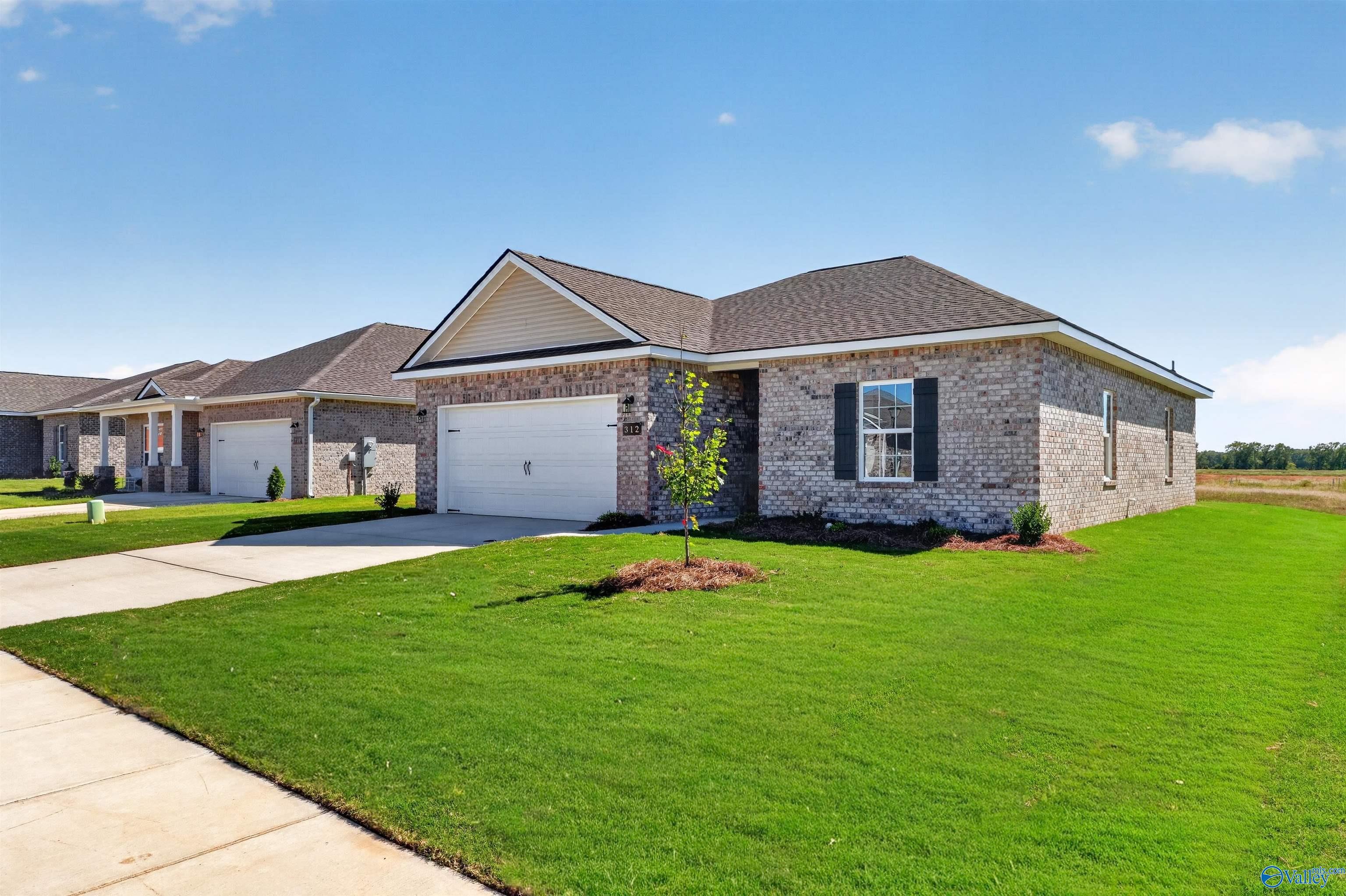 Brick exterior of The Butler floor plan by Davidson Homes with 2-car garage and landscaped yard in Clearview, Hazel Green, Alabama