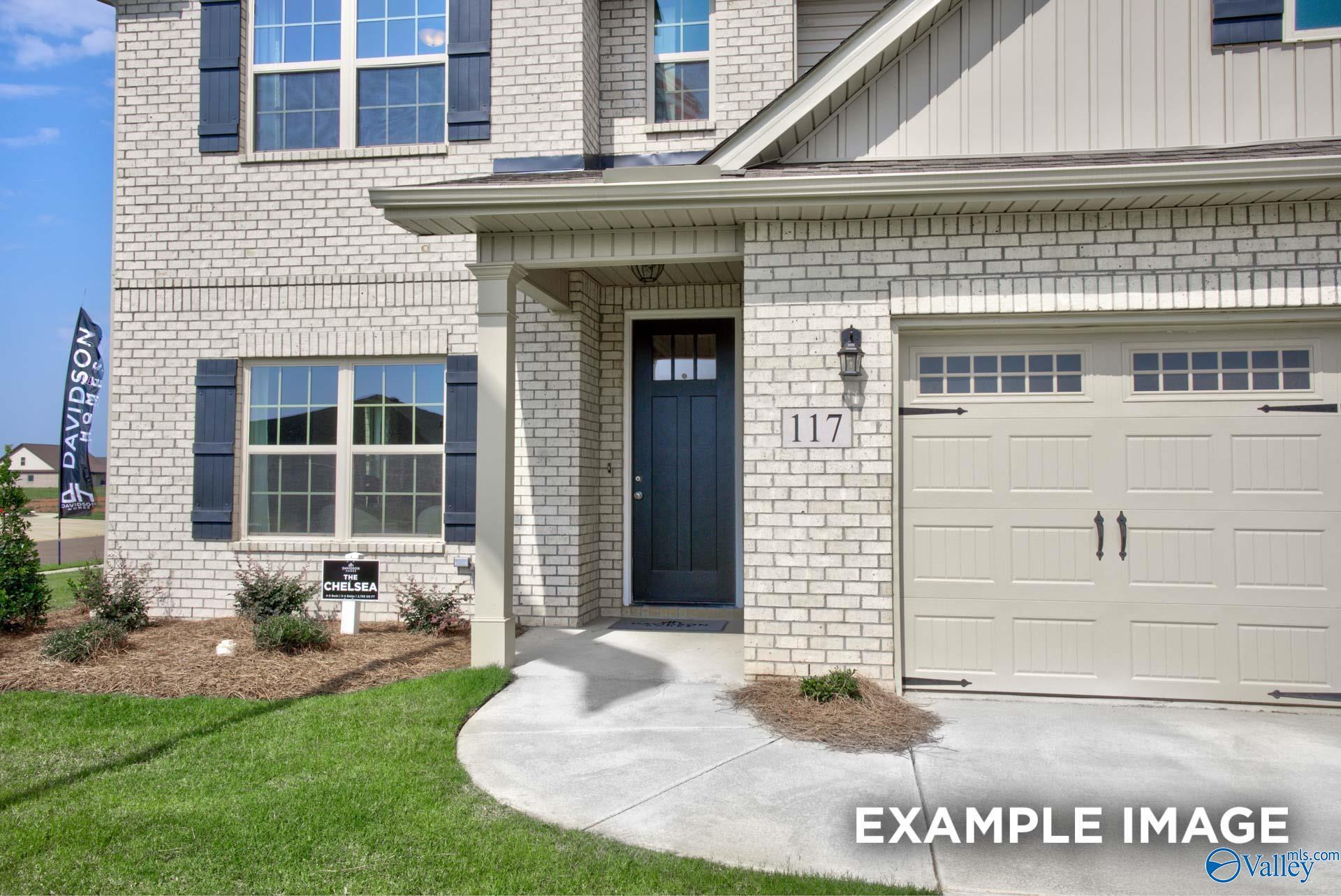 White brick front exterior with covered porch, black shutters, and 2-car garage of Davidson Homes The Chelsea A in Ivy Hills, Toney, Alabama