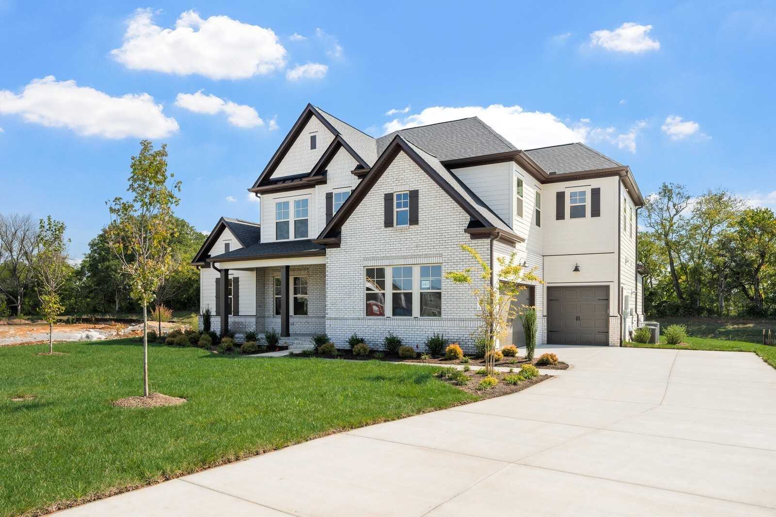 Modern two-story white brick home with black accents, three-car garage, and landscaped yard in Shelton Square, Murfreesboro, Tennessee - Davidson Homes The Albany A