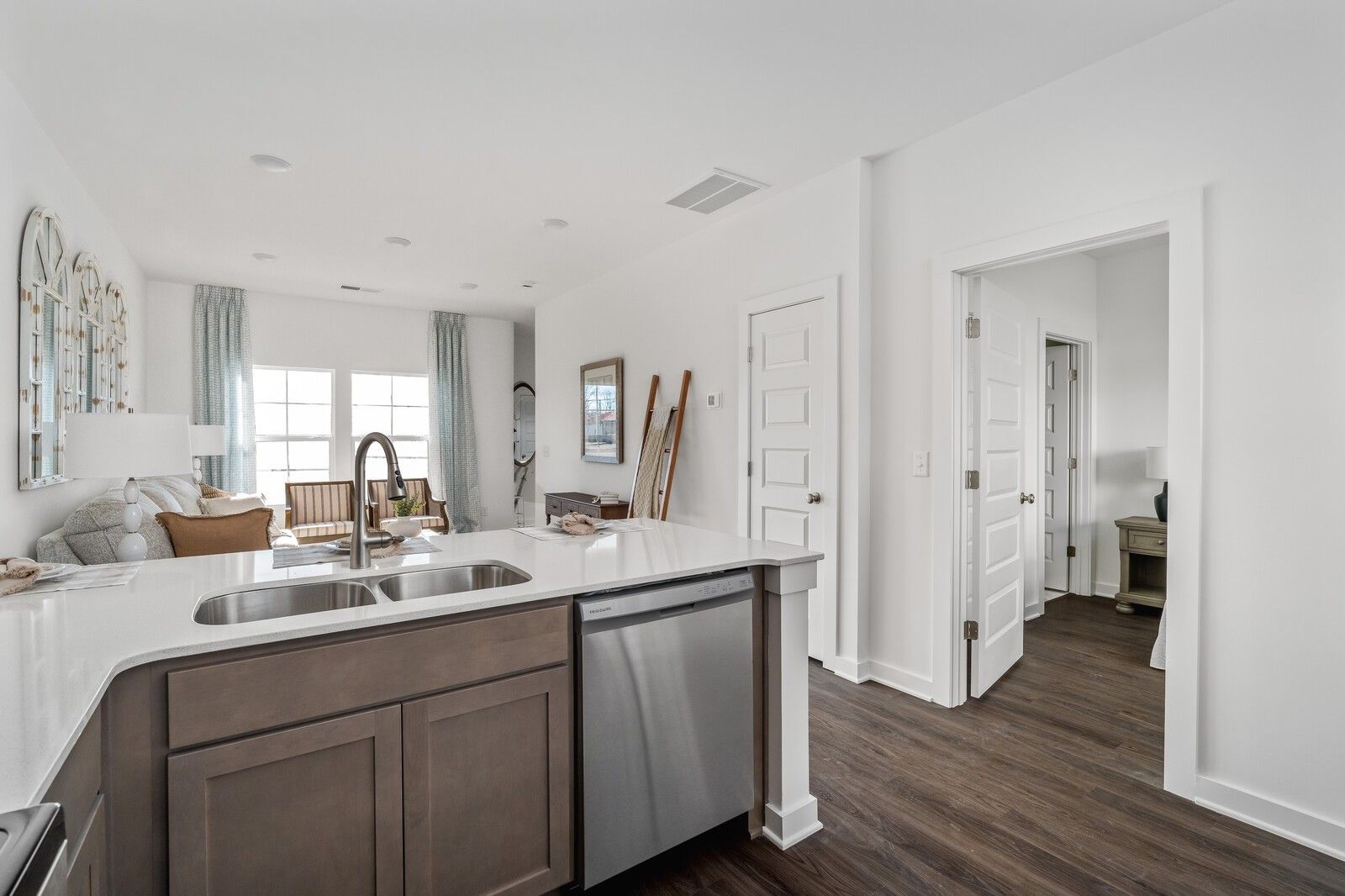 Open-concept kitchen with taupe island, double sink, stainless dishwasher in Davidson Homes The Cumberland A, Gallatin TN