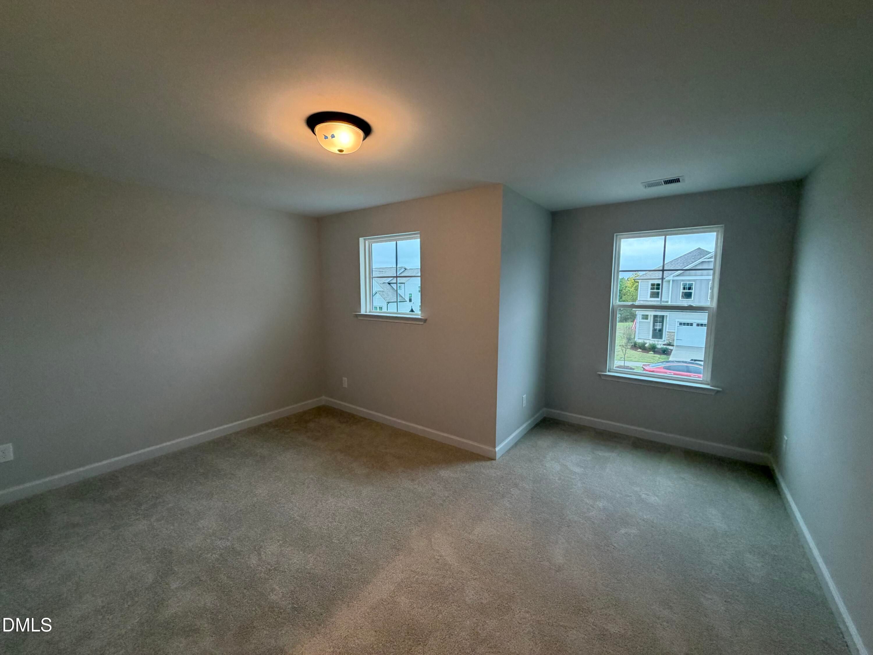 Spacious carpeted bedroom with dual windows and ceiling light in Davidson Homes The Preston C, Wendell Ridge, North Carolina