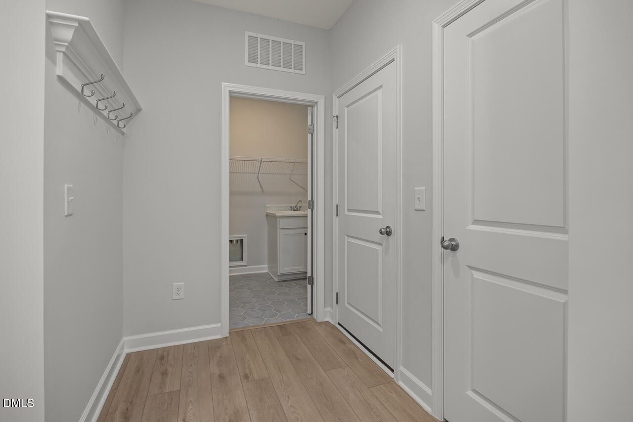 Mudroom entryway with coat hooks and laundry room access in The Birch II E floor plan at Sage on North Main, Wake Forest.