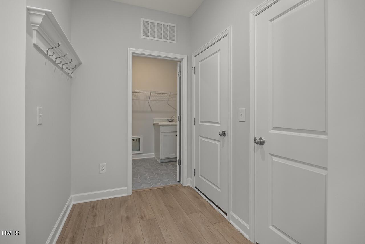 Mudroom entryway with coat hooks and laundry room access in The Birch II E floor plan at Sage on North Main, Wake Forest.