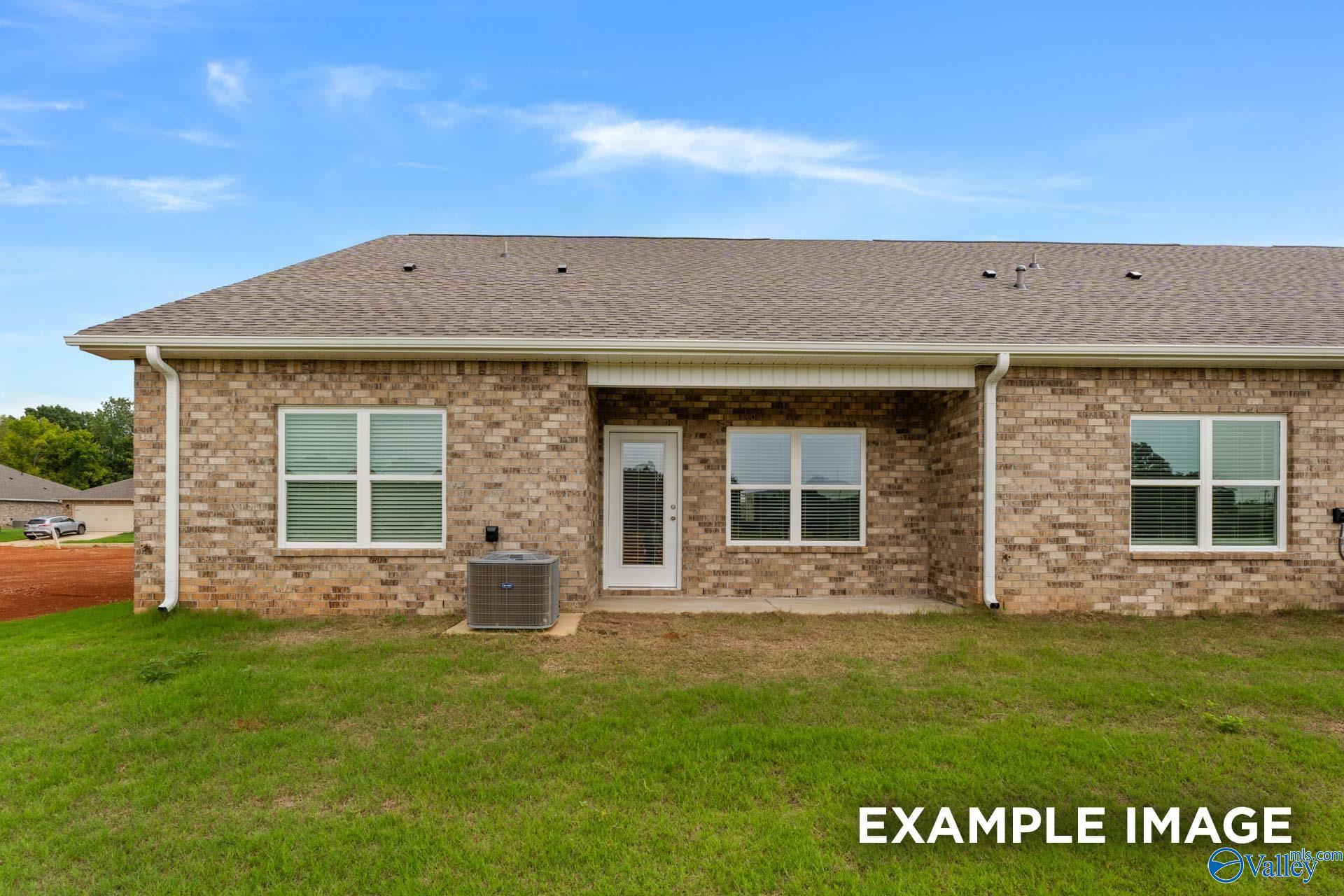 Back view of single-story brick Cumberland B home with covered patio, large windows, and green yard in The Retreat at Hollon Meadow, Decatur, Alabama