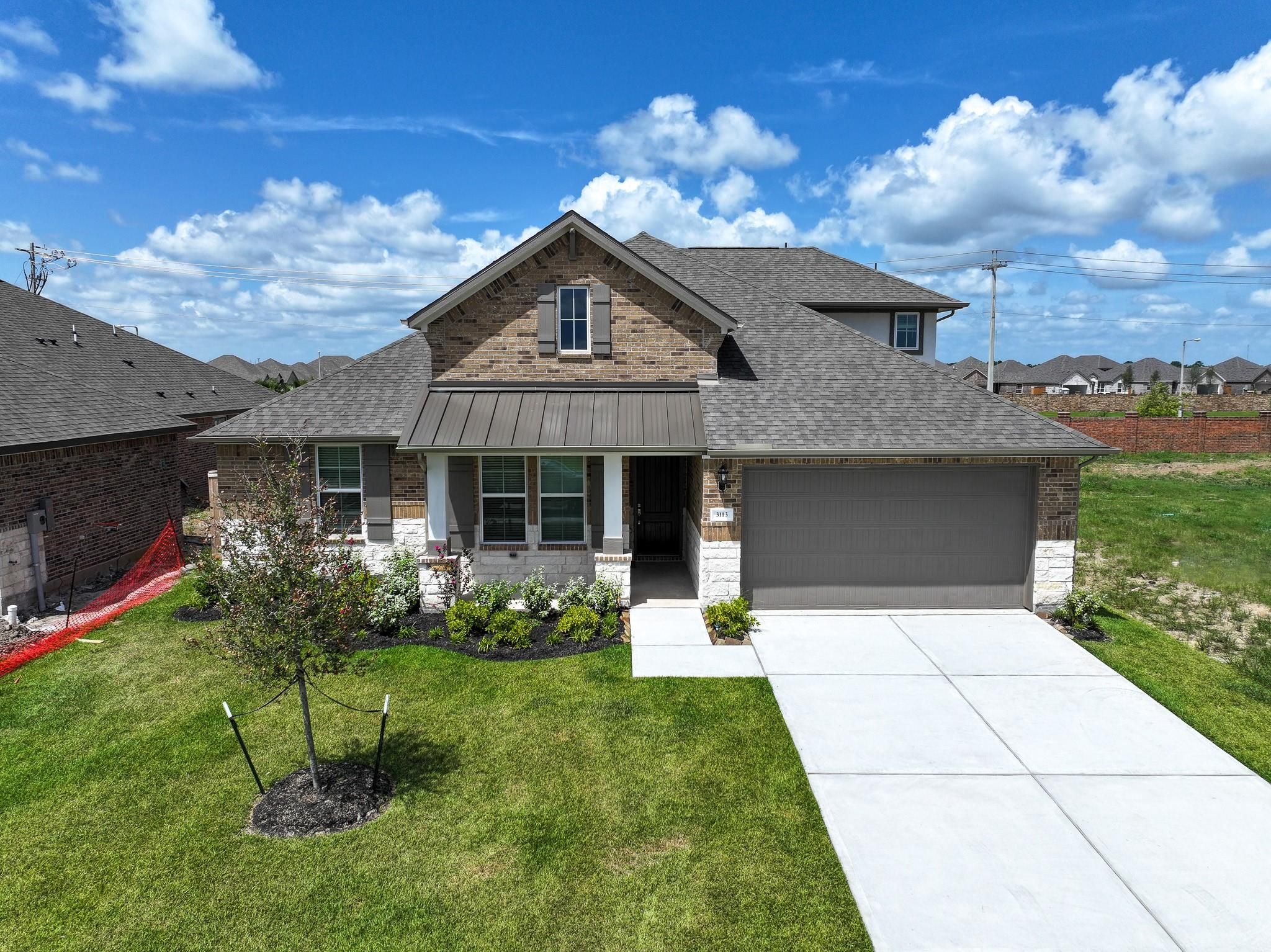 Modern 4-bedroom single-story home with brick facade, 2-car garage, and landscaped front yard in Lago Mar, Texas City, Davidson Homes The Edward C