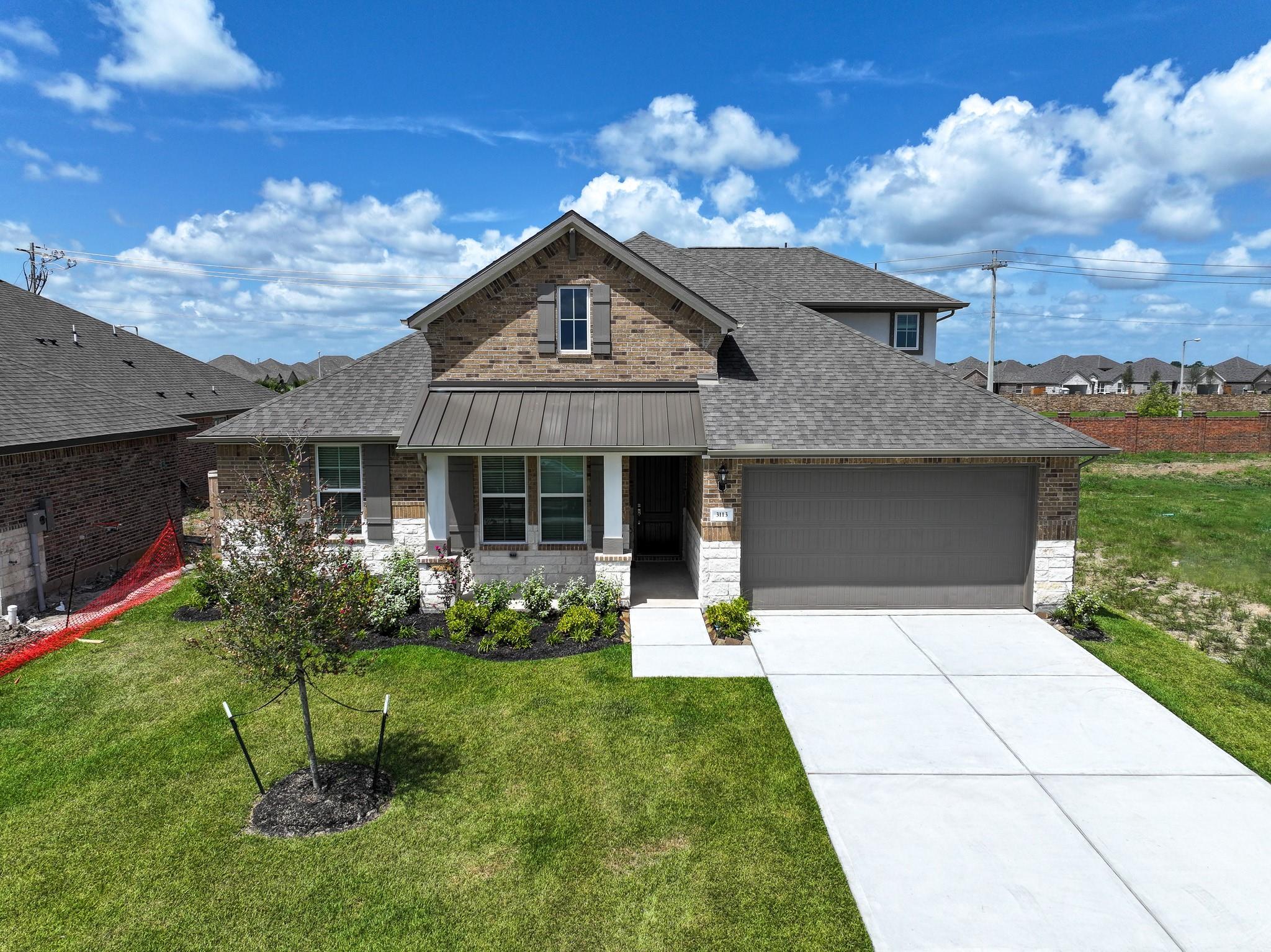 Modern 4-bedroom single-story home with brick facade, 2-car garage, and landscaped front yard in Lago Mar, Texas City, Davidson Homes The Edward C