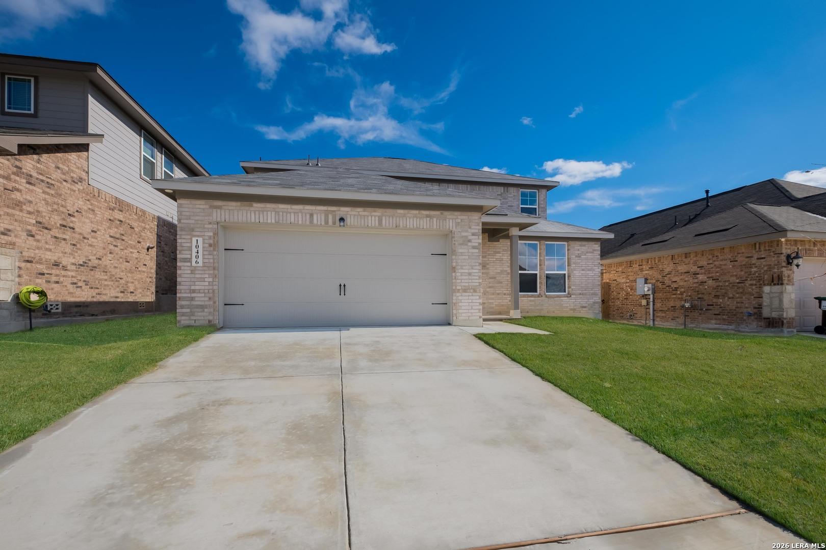Modern two-story brick home with 2-car garage, driveway, and lush green lawn in Bricewood, San Antonio, Texas - Davidson Homes Douglas E
