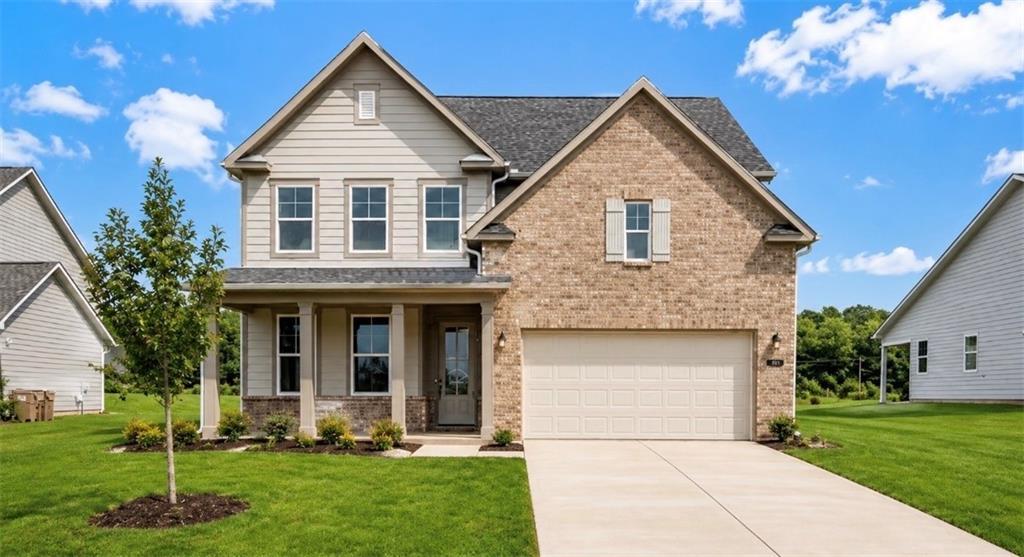 Two-story Hickory C floor plan by Davidson Homes with brick exterior, 2-car garage, and front porch in Wehunt Meadows, GA.