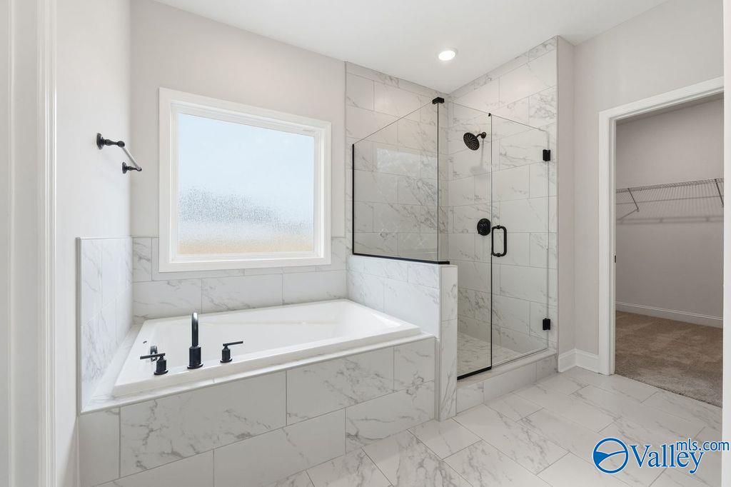 Modern master bathroom with freestanding tub, glass walk-in shower, white subway tile in Davidson Homes Rockford B, Hartselle AL