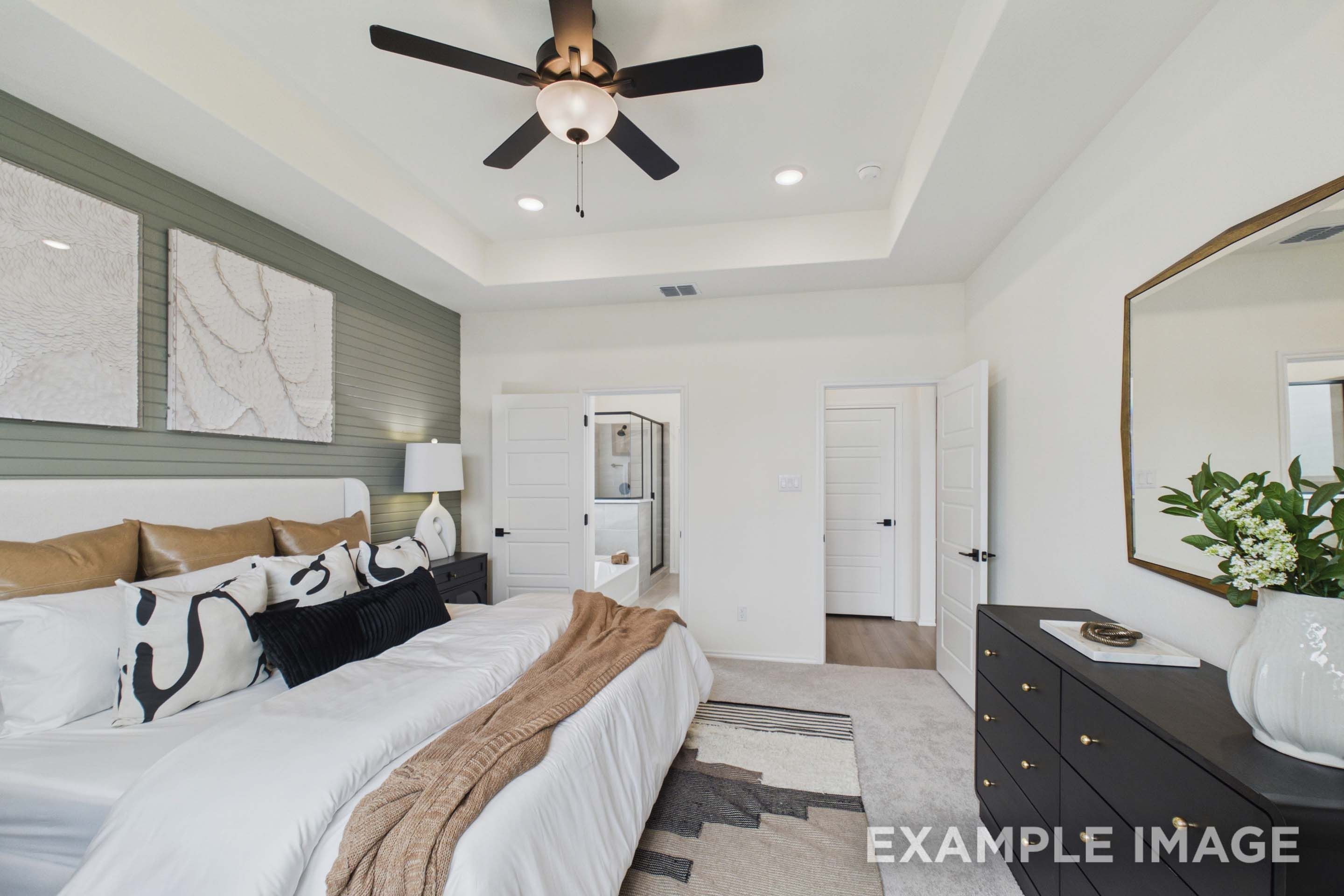 Spacious master suite on main floor of The Laurel G featuring tray ceiling, modern shiplap accent wall, and ensuite bath.