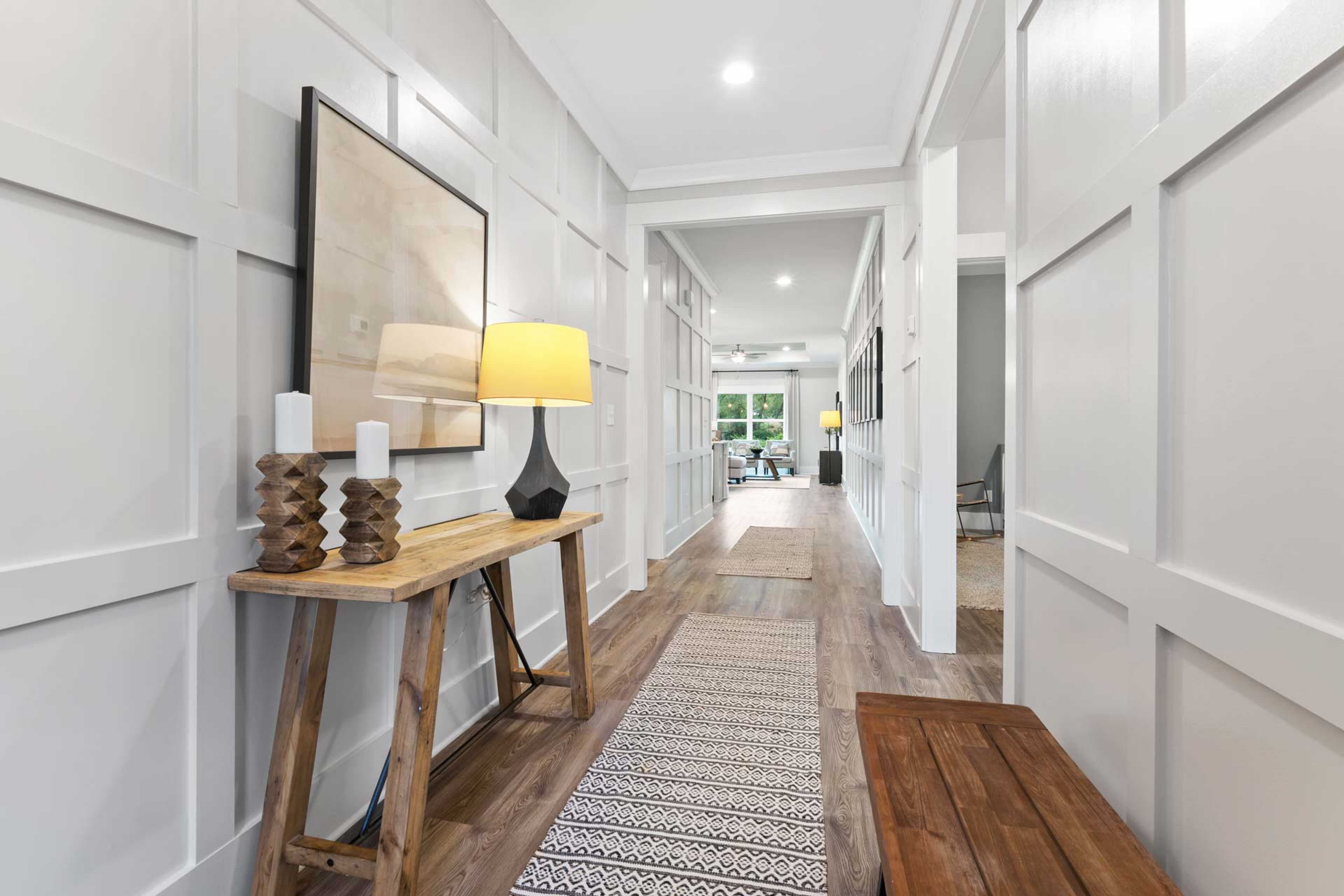 Elegant foyer hallway at The Meadows in Athens AL with shiplap walls, hardwood floors, console table and lamp