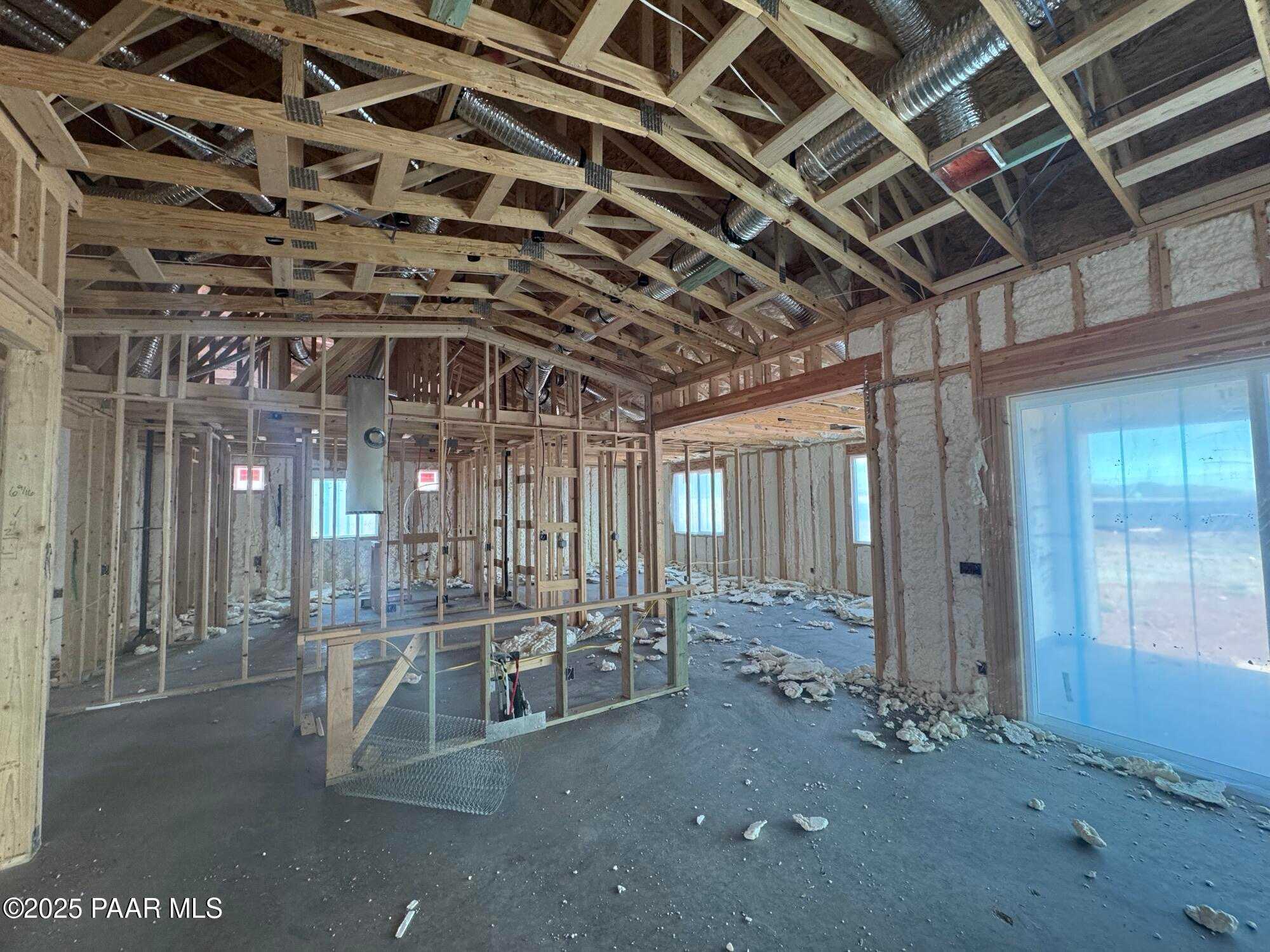 Exposed wooden framing, insulation, and ductwork in open great room of The Sunrise A 3-bedroom home, Prescott Valley, Arizona