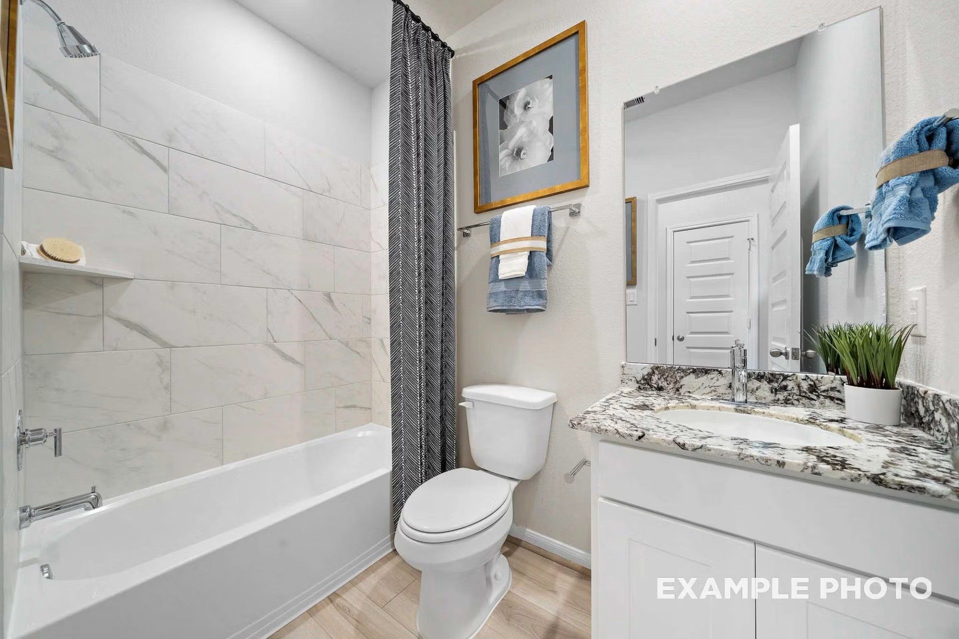 Modern bathroom with marble-style tile shower, granite vanity, and white cabinetry in Davidson Homes San Marcos E floor plan.