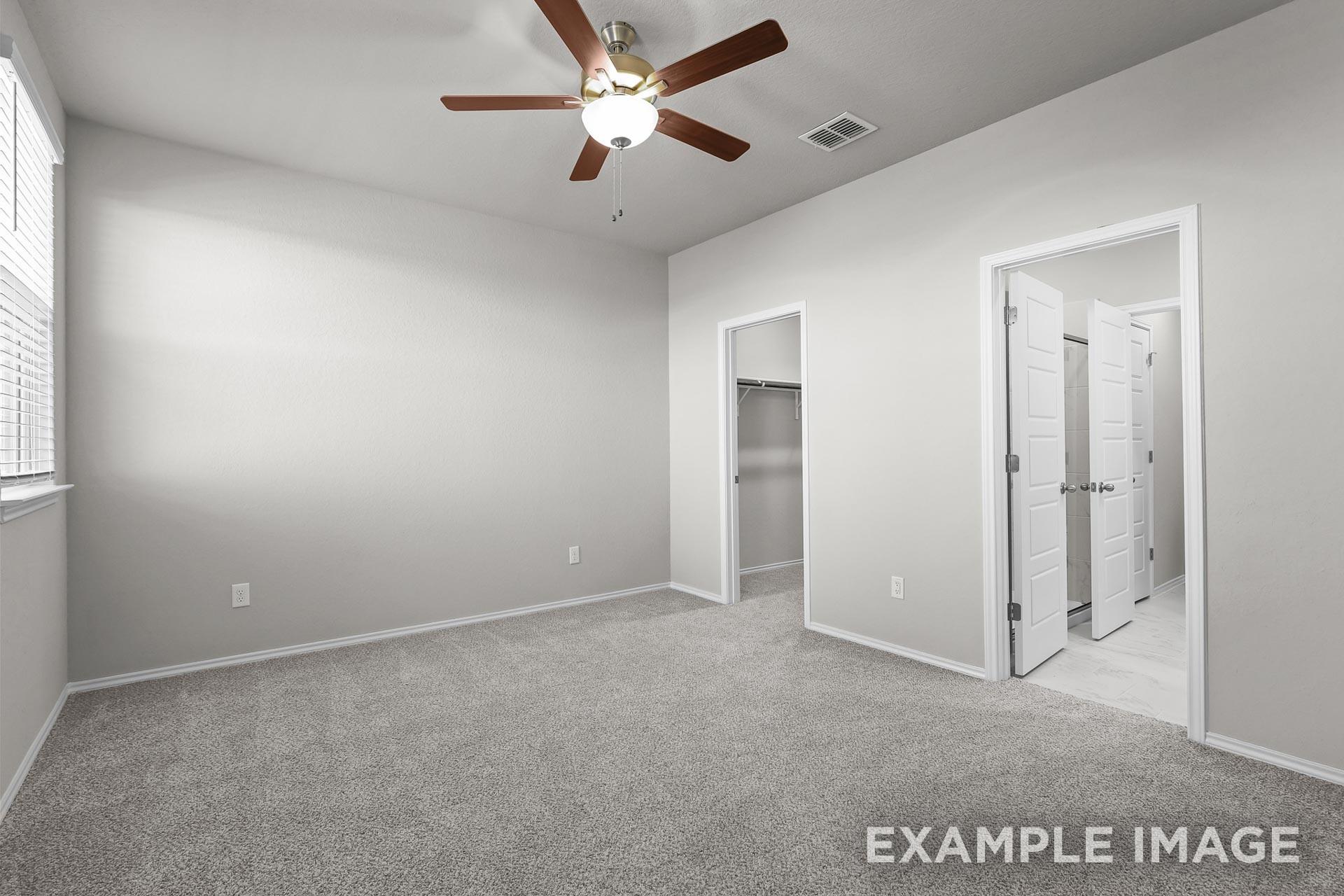Spacious bedroom with walk-in closet and ensuite bathroom in Davidson Homes The Colorado G floor plan, Heartland, Texas.