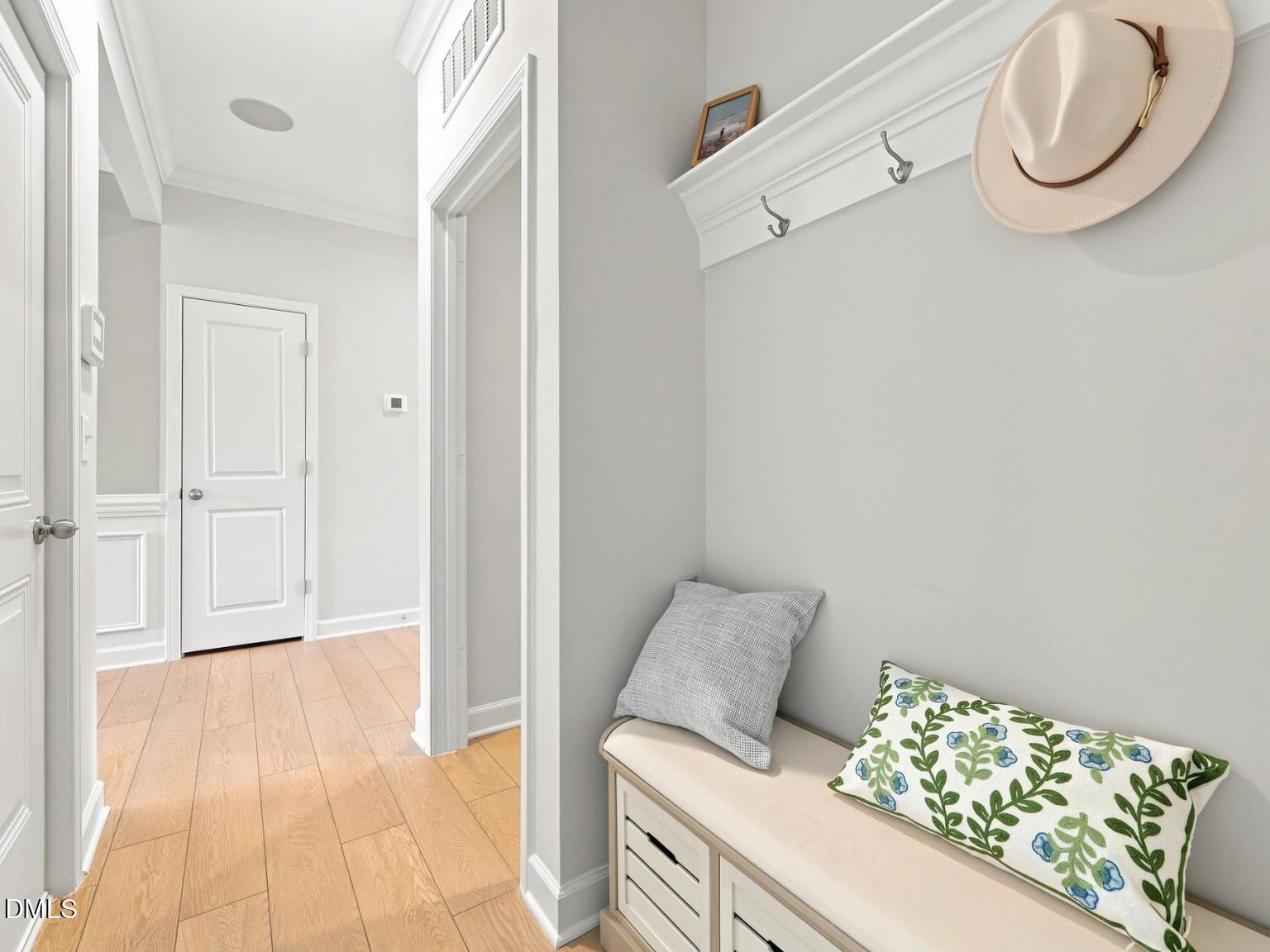 Entryway mudroom bench with storage and wall hooks in The Daphne C floor plan by Davidson Homes in Zebulon, North Carolina.