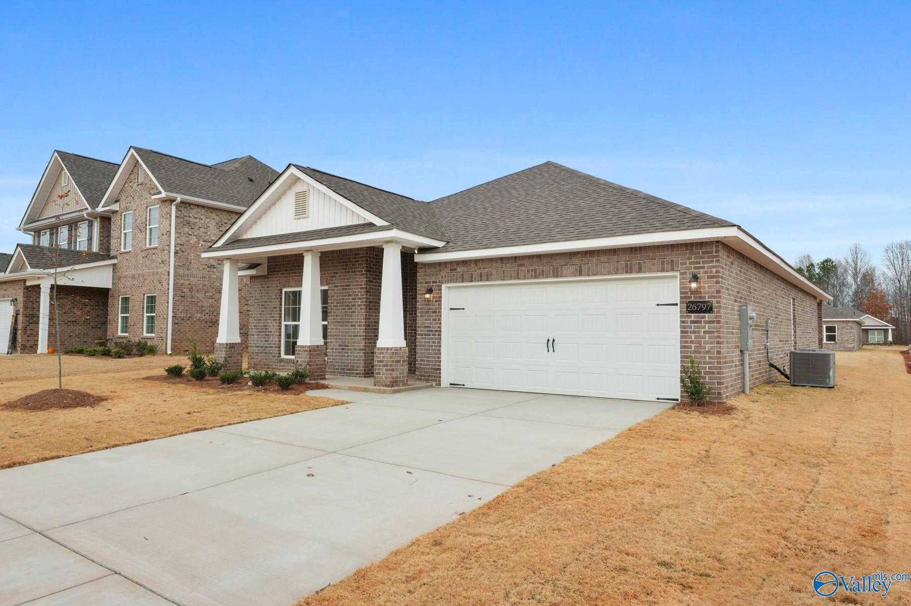 Brick single-story 4-bedroom home with 2-car garage, front porch, and landscaped yard in Ricketts Farm, Athens, Alabama