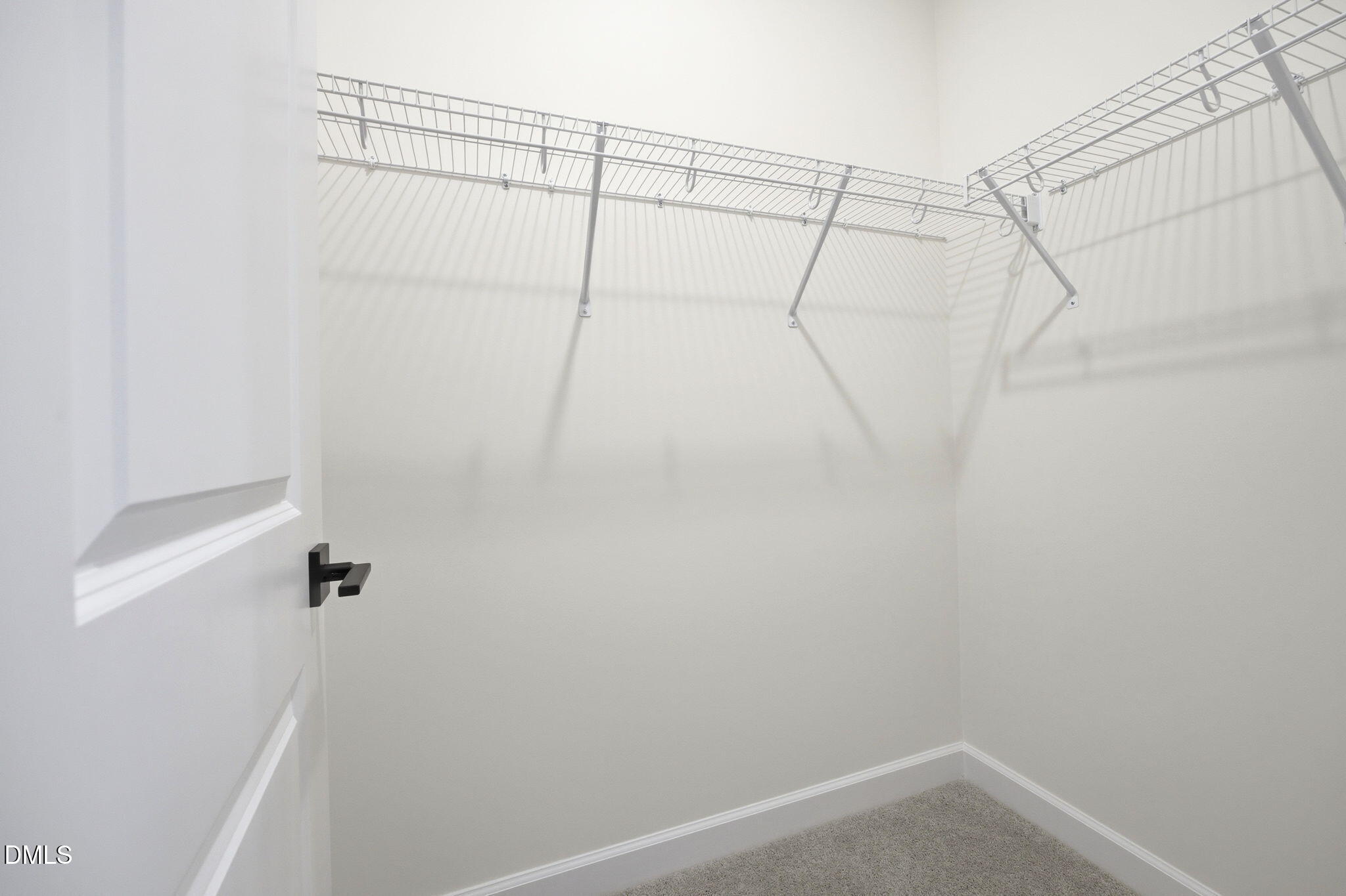 Walk-in closet with wire shelving in The Ashport M floor plan at Wendell Ridge in Wendell, North Carolina.