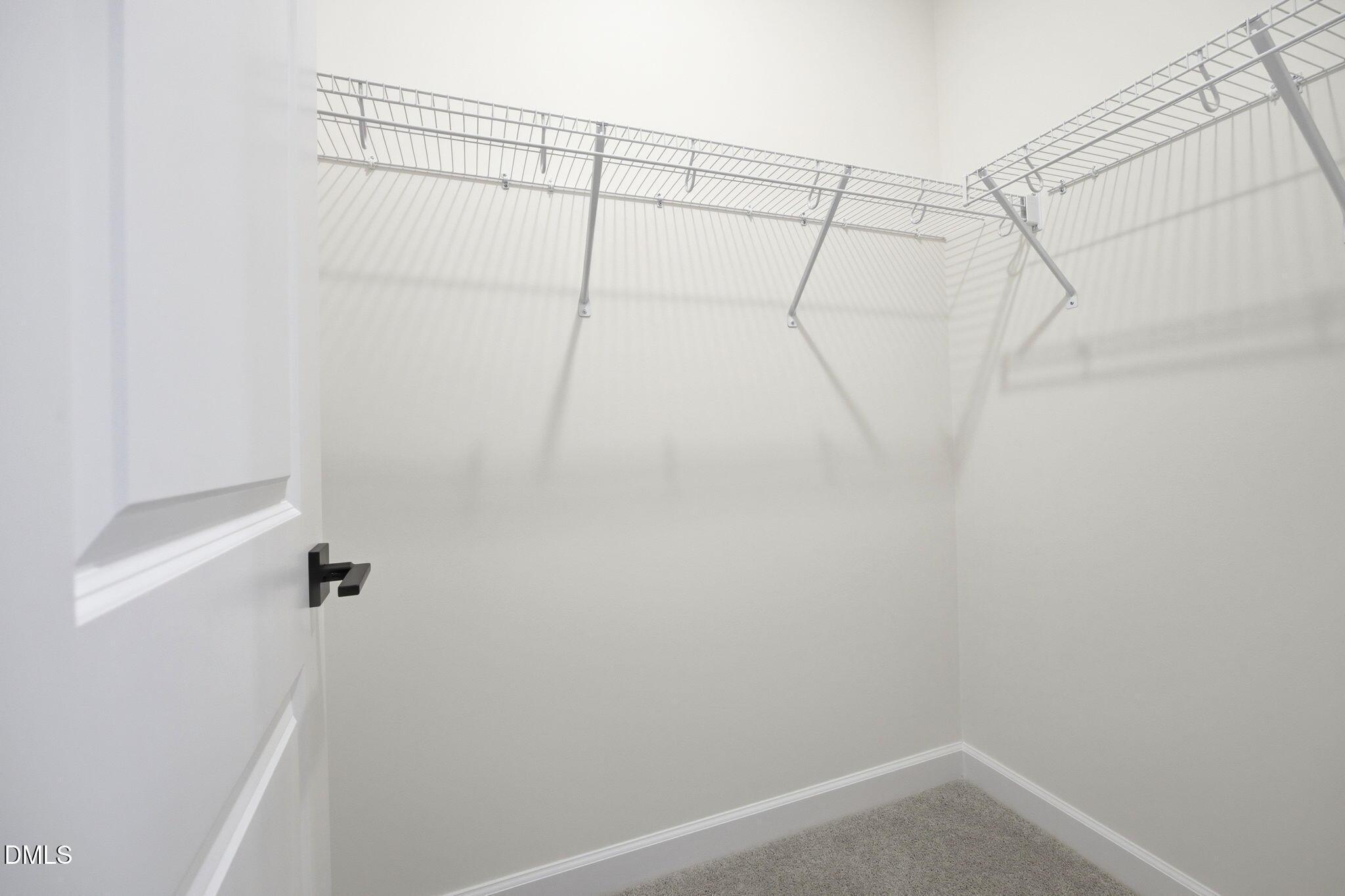 Walk-in closet with wire shelving in The Ashport M floor plan at Wendell Ridge in Wendell, North Carolina.
