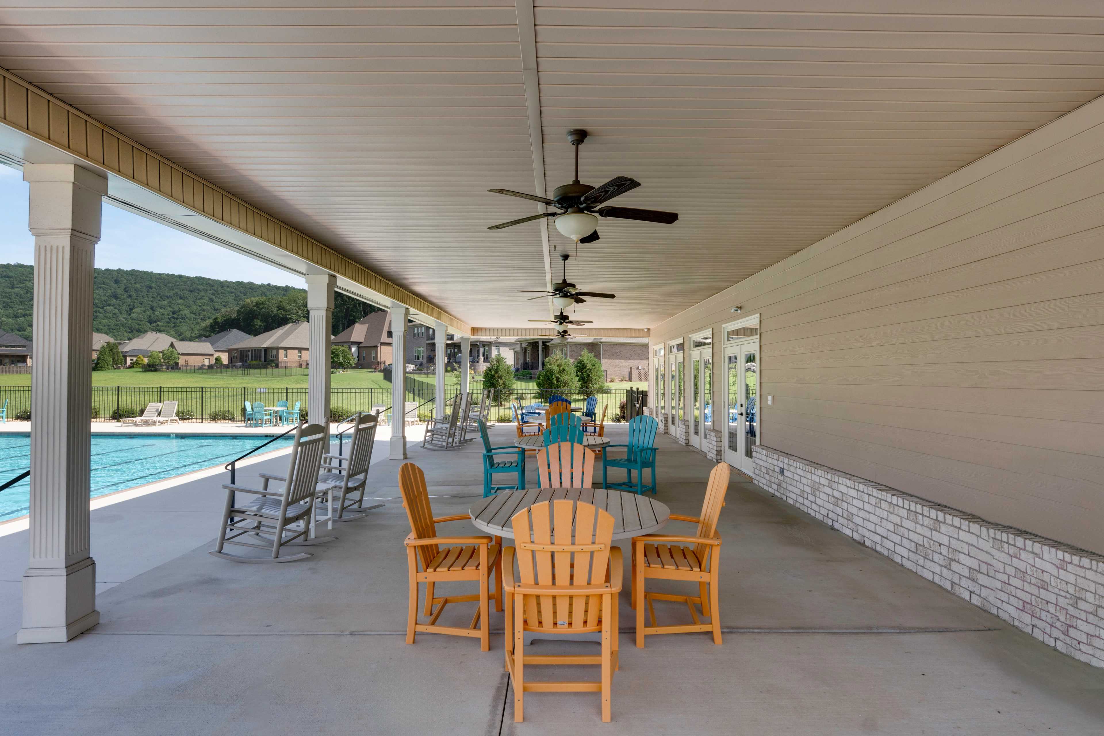 Covered poolside pavilion at The Meadows at Hampton Cove in Owens Cross Roads Alabama featuring Adirondack chairs and ceiling fans