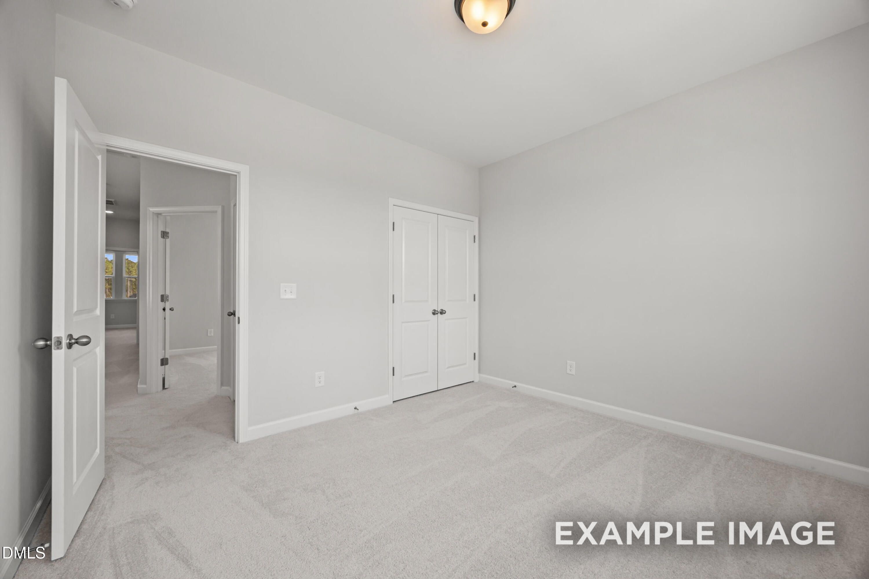 Bright secondary bedroom with neutral carpet and double-door closet in The Alexander B floor plan, Forestville Yard.