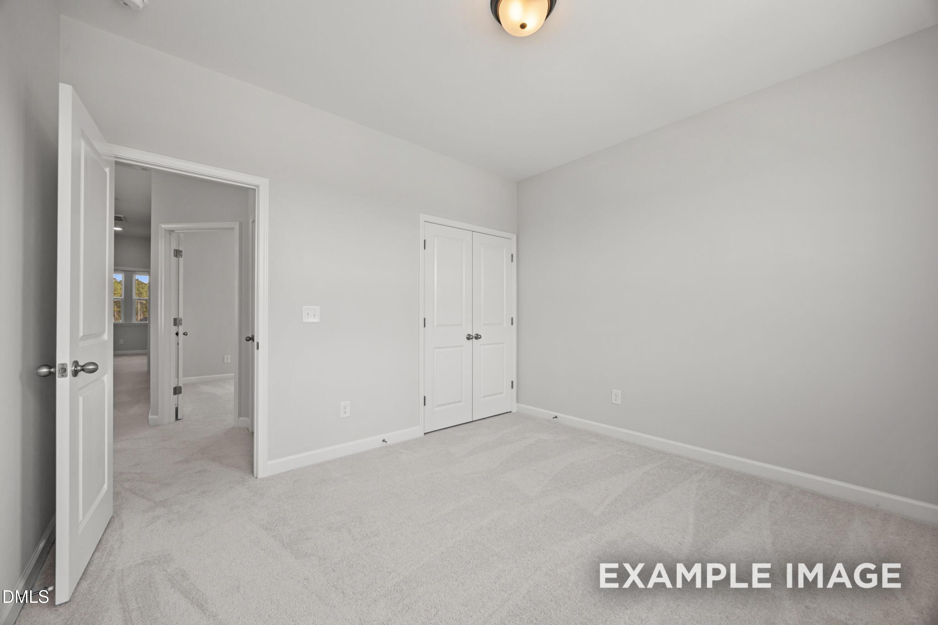 Bright secondary bedroom with neutral carpet and double-door closet in The Alexander B floor plan, Forestville Yard.