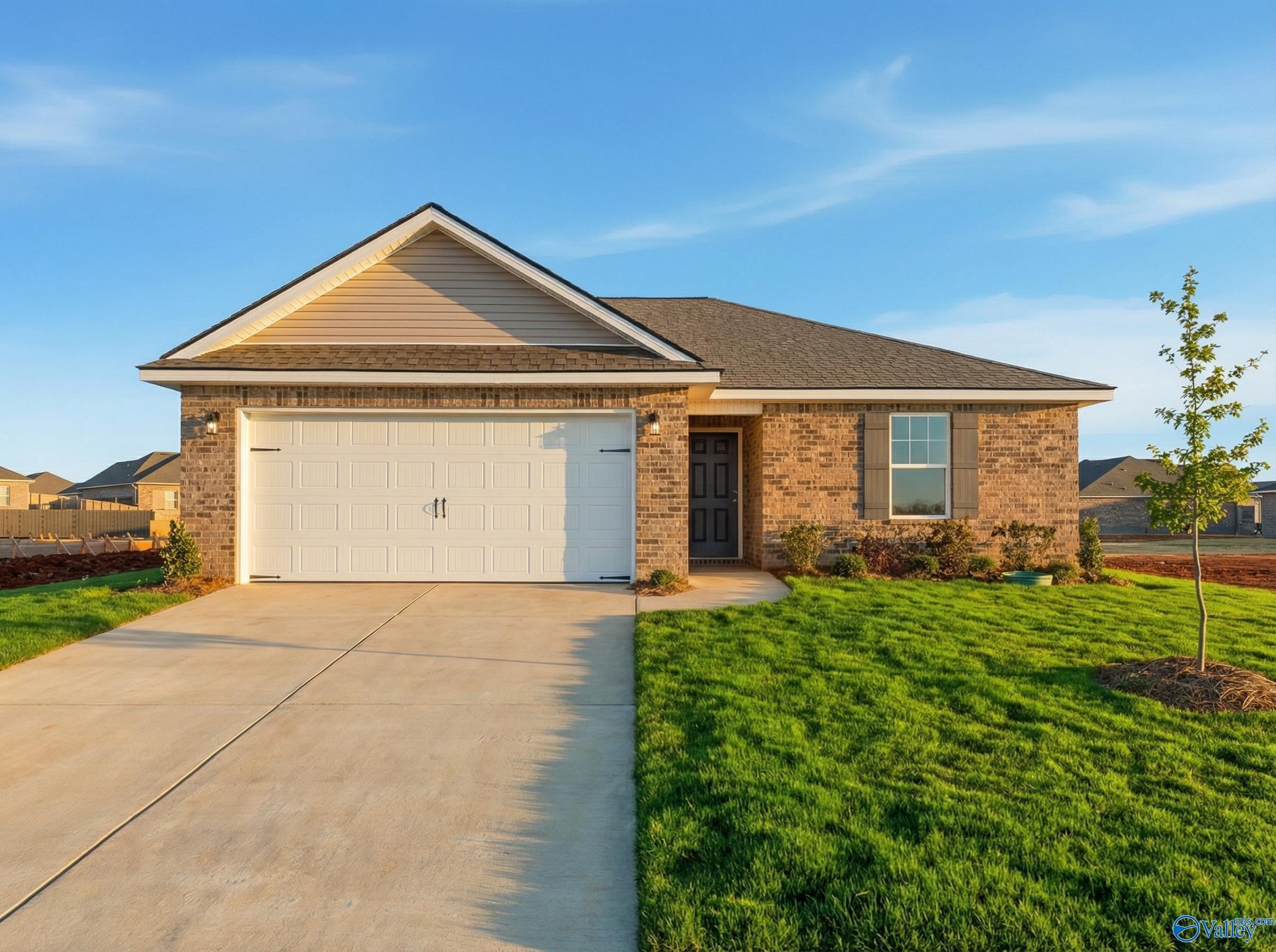Modern 1-story The Butler home with white 2-car garage, brick accents, and green lawn in Heritage Lakes, New Market, Alabama